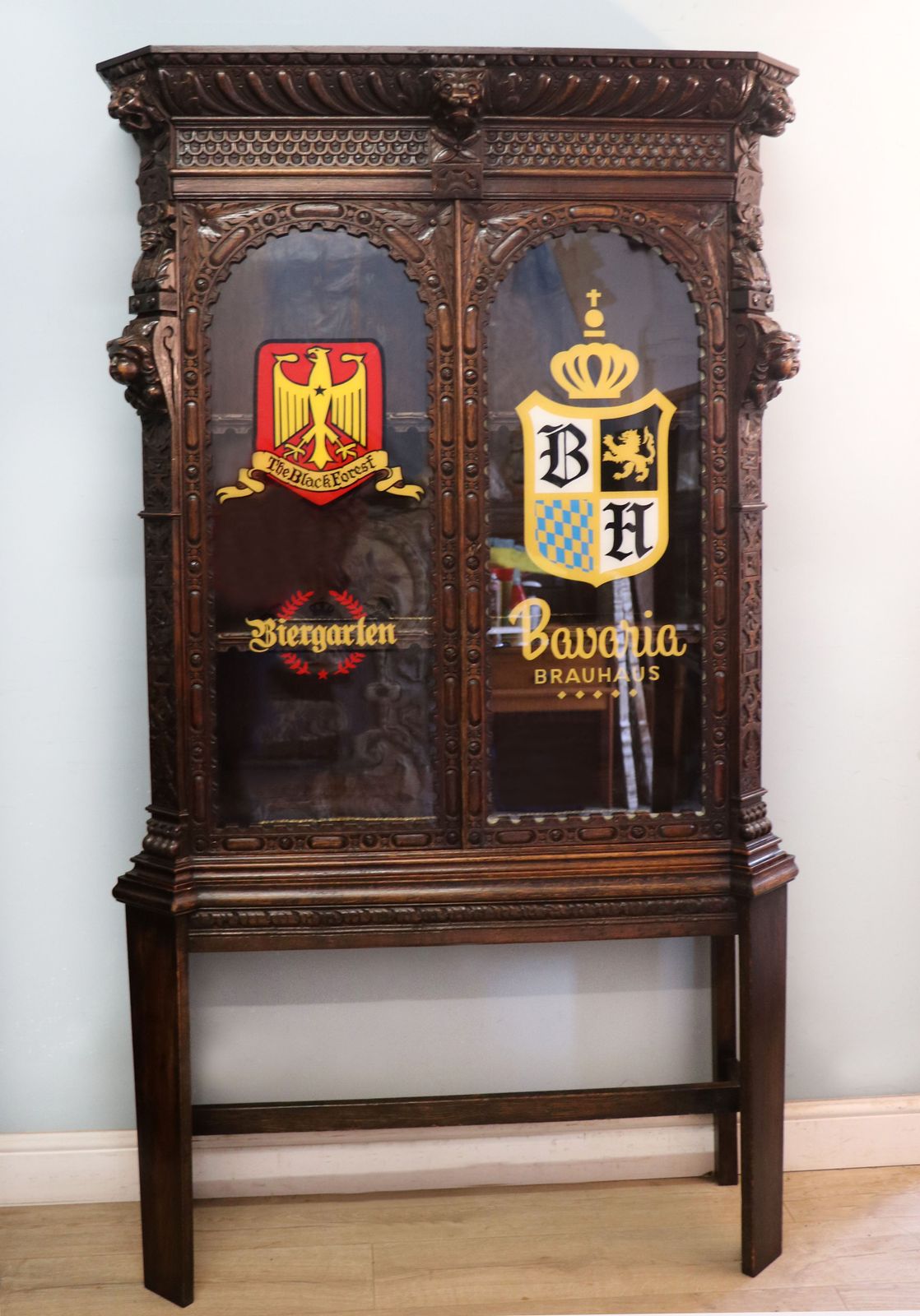 A Lovely Late 19th Heavily Carved Oak Bookcase Cabinet On Stand, Later Sign Written With A Selection Of German Beer Related Emblems.