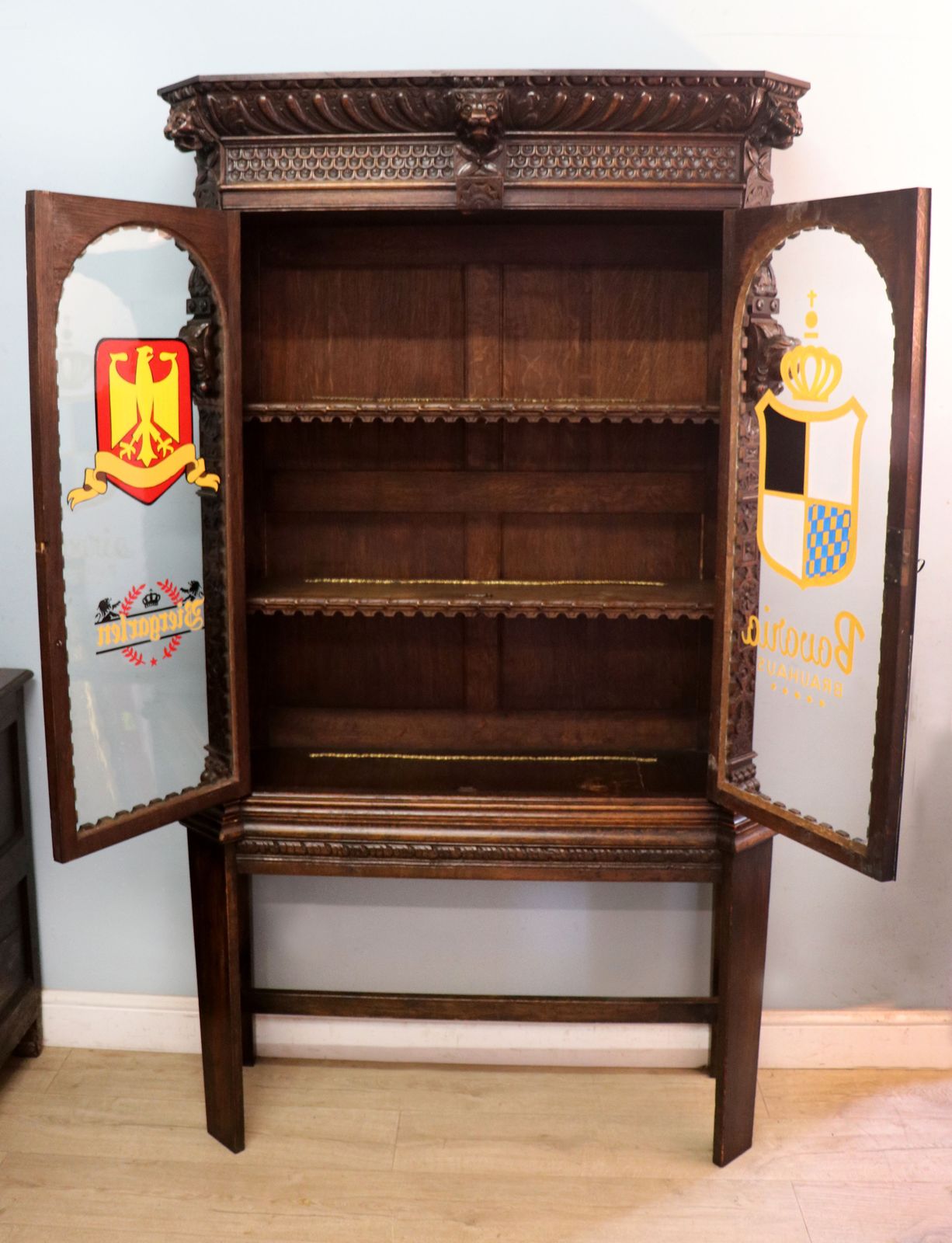 A Lovely Late 19th Heavily Carved Oak Bookcase Cabinet On Stand, Later Sign Written With A Selection Of German Beer Related Emblems. photo for sale