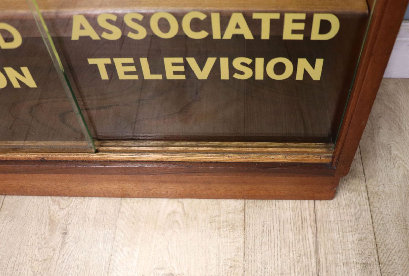 A Lovely Mid Century Display Cabinet Later Sign Written With The Emblems And Wording For Associated Television. photo vintage