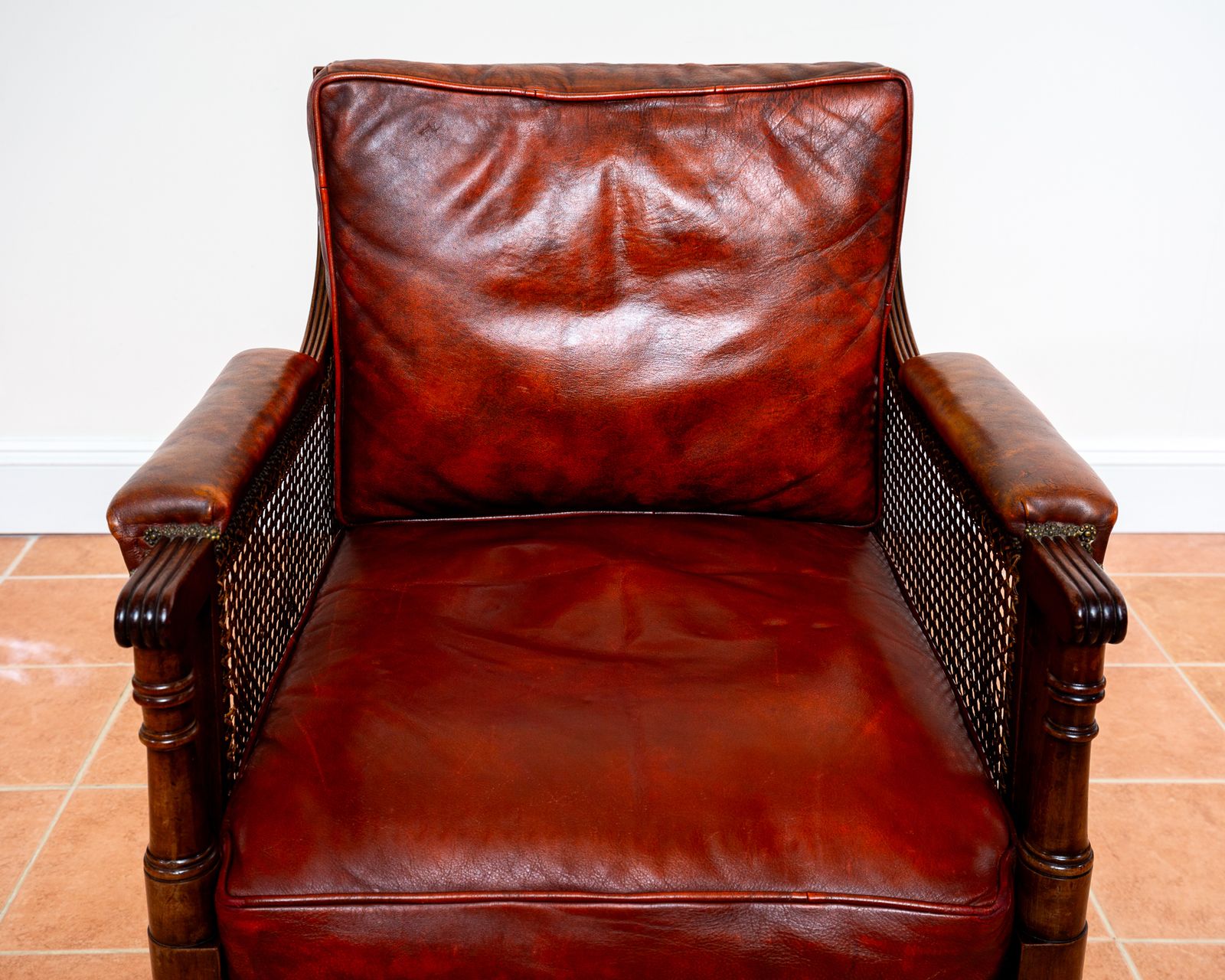 photo vintage Fine Regency Bergere Leather Library Chair 1810 1820 Georgian Reading Red Leather Armchair Carved Cane Rattan Brass Castors