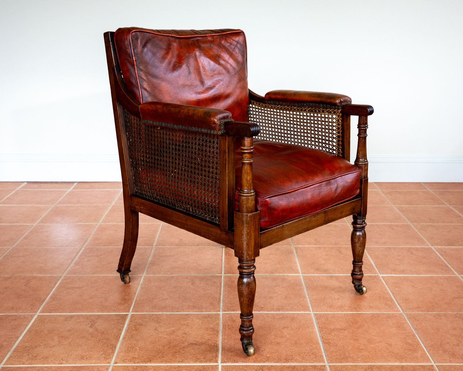 photo for sale Fine Regency Bergere Leather Library Chair 1810 1820 Georgian Reading Red Leather Armchair Carved Cane Rattan Brass Castors