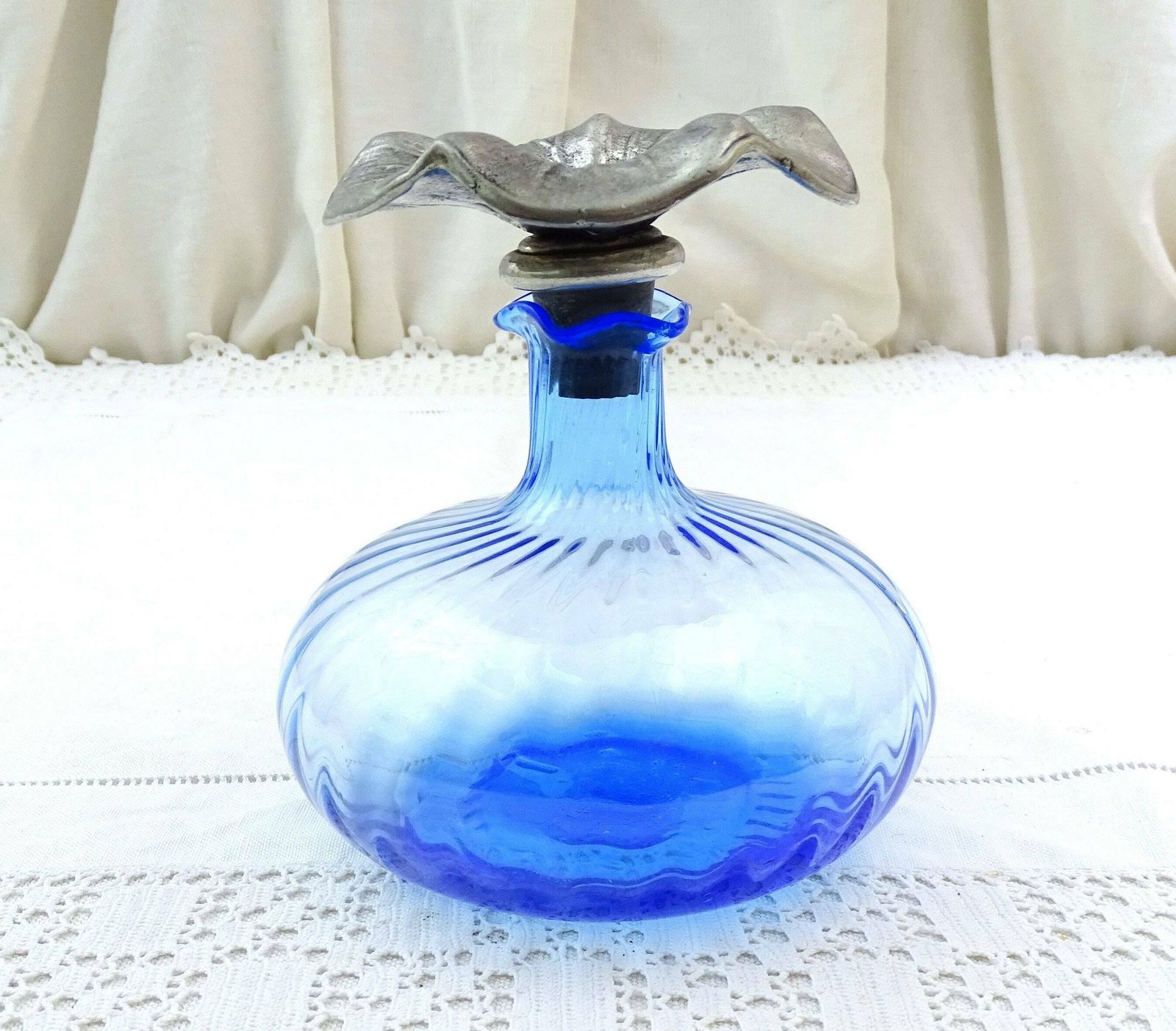 Flacon d'eau de cologne vintage en verre bleu, bouchon fleur en étain, France photo for sale
