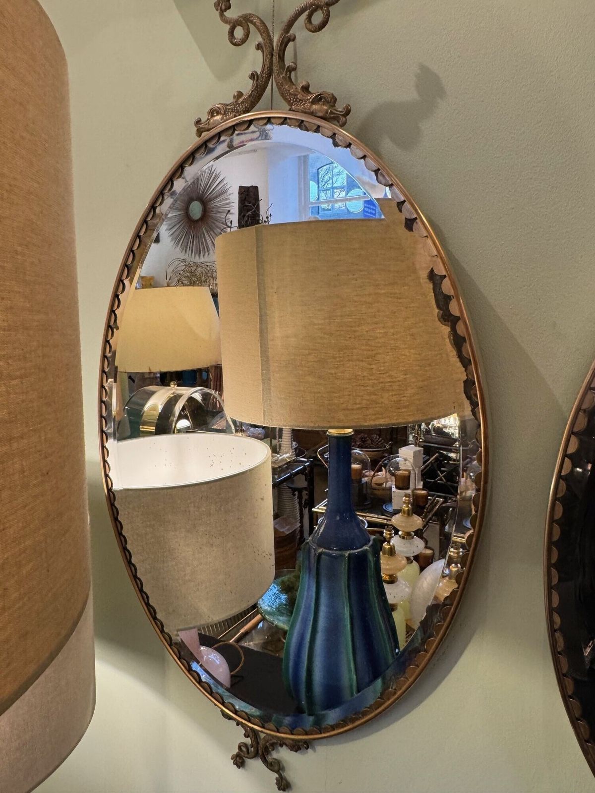 A Pair Of Italian 1940s Oval Mirrors With Dolphin Detailing Around The Brass Frame photo furniture