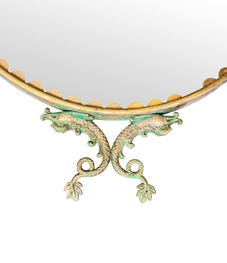 3250.0 A Pair Of Italian 1940s Oval Mirrors With Dolphin Detailing Around The Brass Frame photo