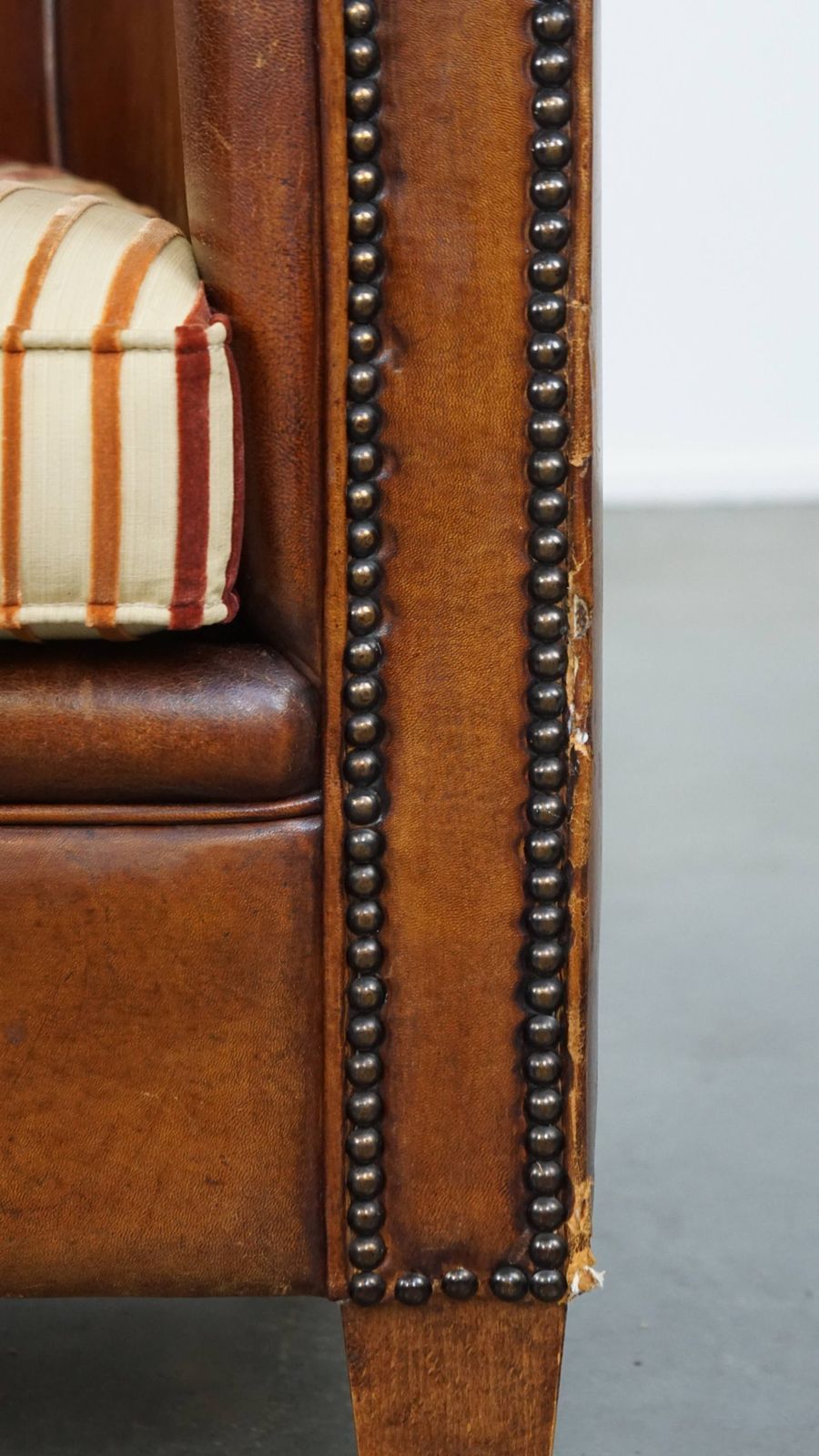 724.7276999999999 Karaktervolle Vintage Clubfauteuil Van Schapenleer In Cognackleur Met Kleurrijk Stoffen Zitkussen photo