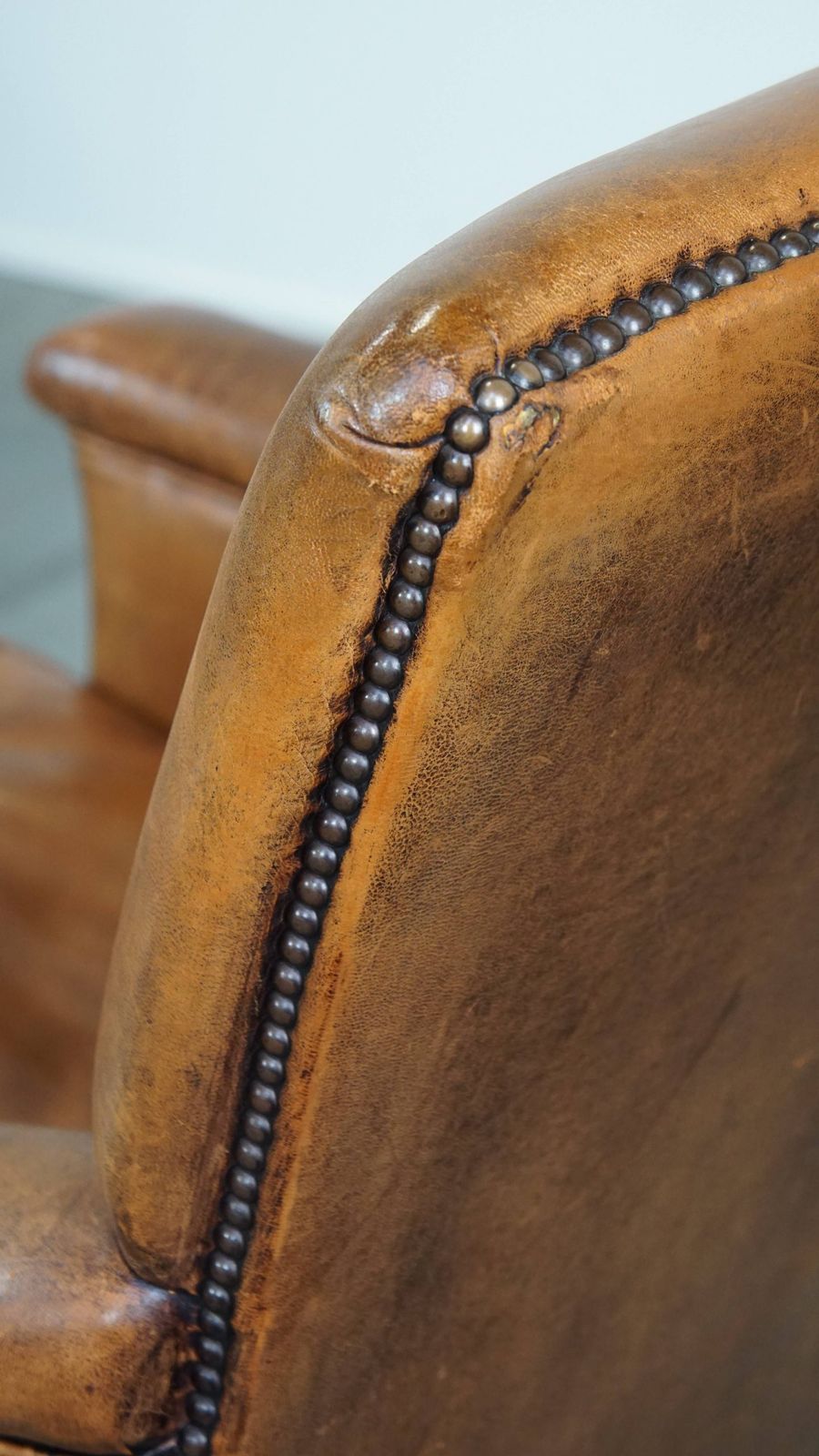photo vinterior Karakteristieke En Comfortabele Fauteuil In Cognackleurig Schapenleer Met Strakke Vormen En Mooie Patina