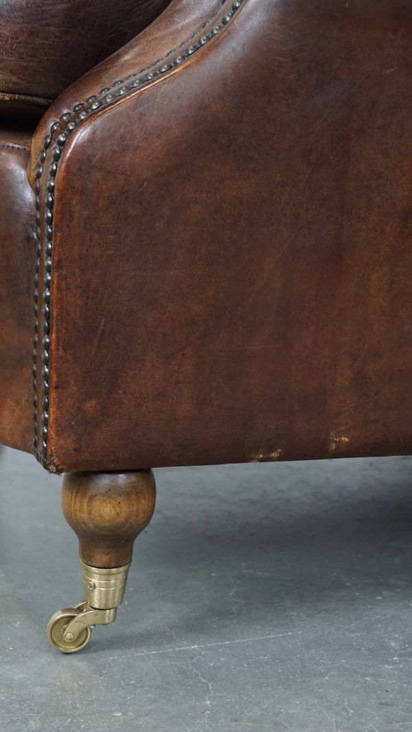 photo vinterior Klassieke Schapenvacht Fauteuil In Donkere Kleur, Goede Staat, Met Ronde Vormen En Op Wieltjes