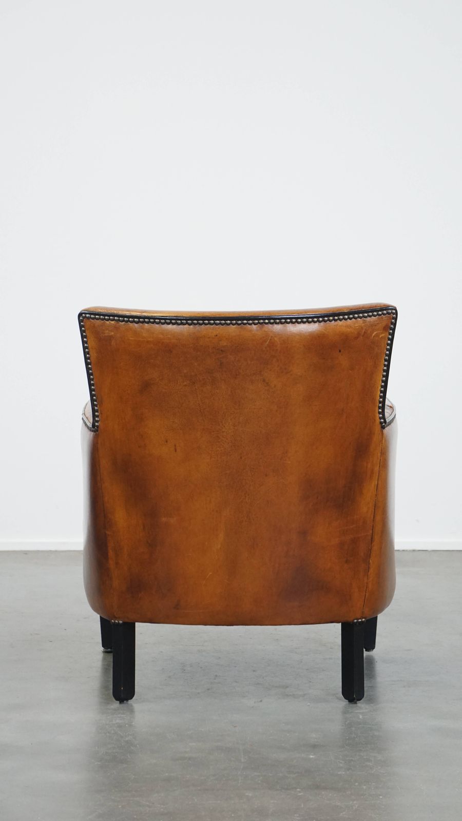 Subtle Cognac Colored Sheepskin Armchair With A Nice Design And Finish With Black Piping And Decorative Nails photo Furniture