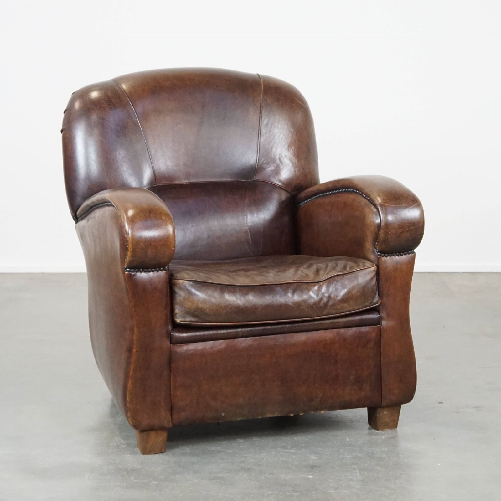 Royal And In Good Condition Dark Sheepskin Armchair With Round Shapes And A Comfortable Seat