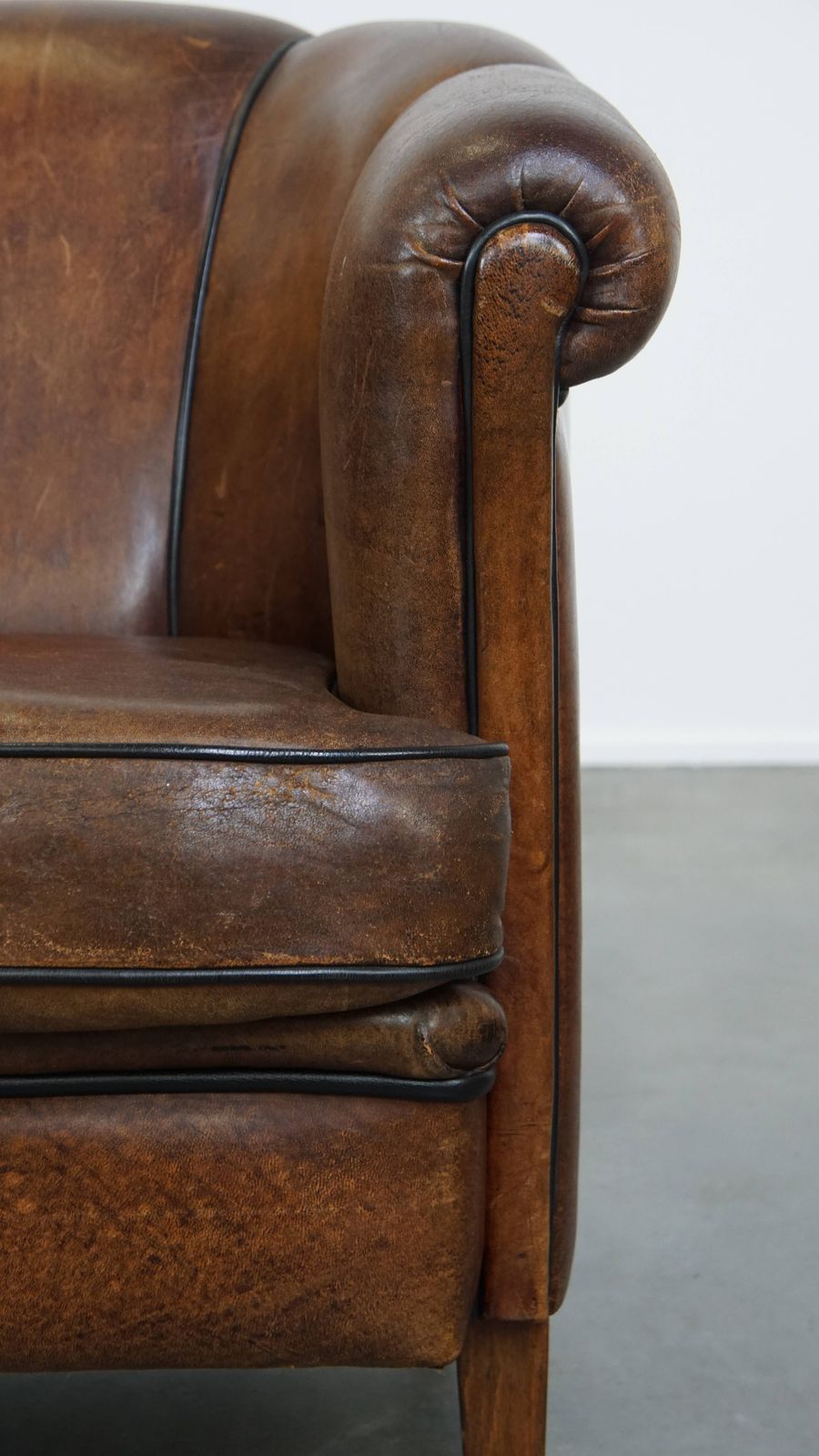 photo furniture Special, Characteristic And Stately Dark Sheepskin Club Chair With A Black Piping Finish