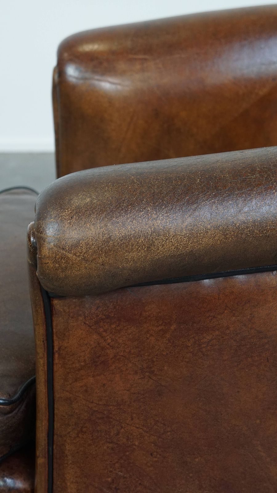 1000.9691999999999 Special, Characteristic And Stately Dark Sheepskin Club Chair With A Black Piping Finish photo