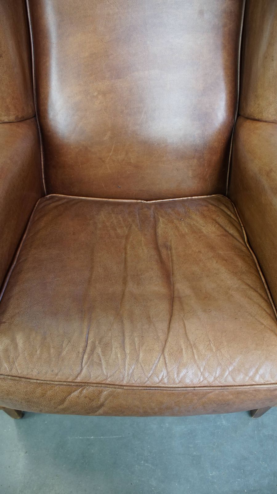 Charming, Timeless And Characterful Cowhide Wing Chair In A Light Cognac Color Finished With A Matching Piping photo vinterior