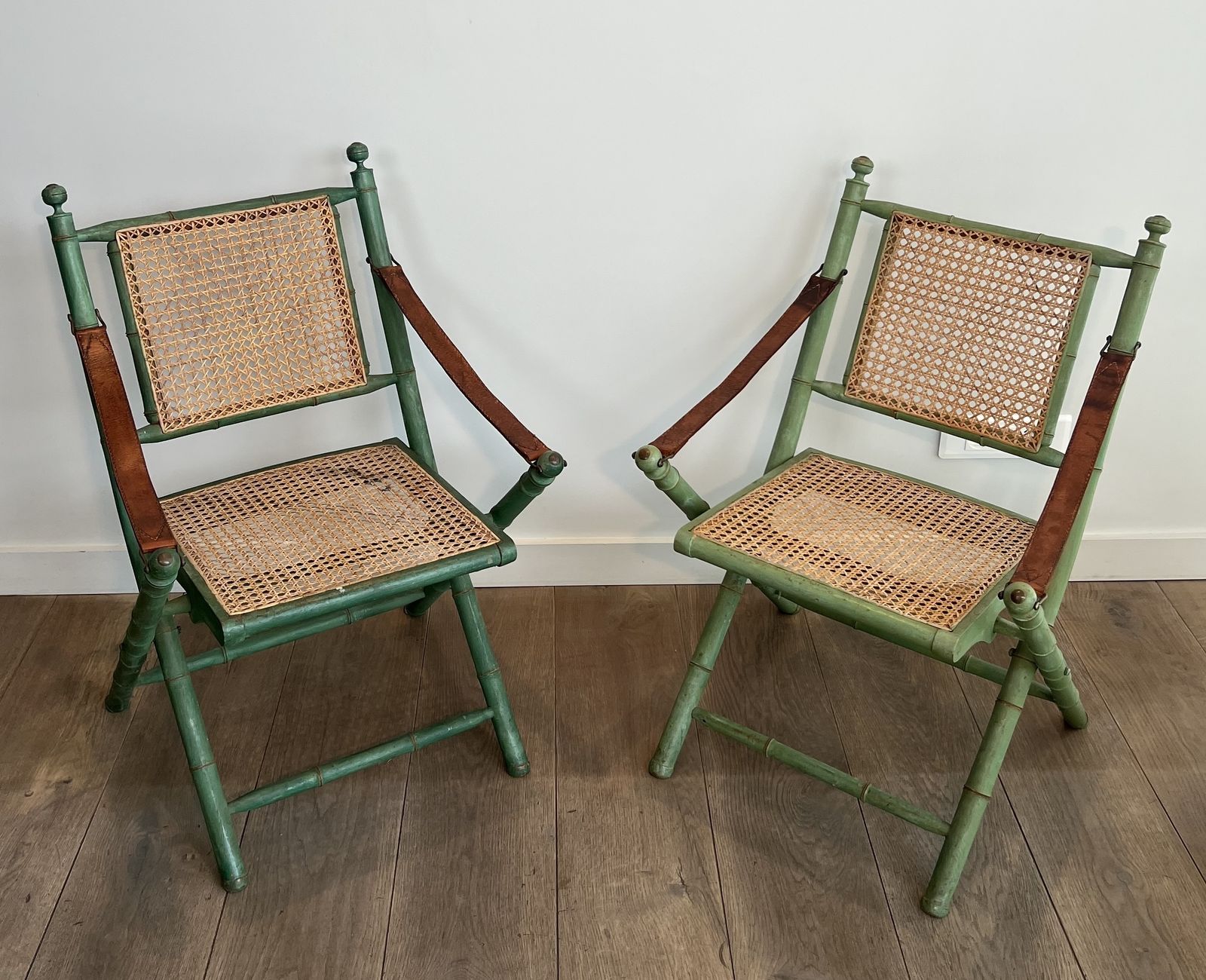 Pair Of Folding Safari Chairs In Weathered Faux Bamboo Style With Caned Backs And Seats And Leather Armrests