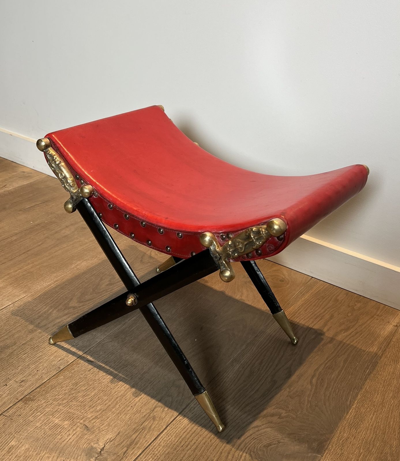 Neoclassical Style Curule Stool In Red Leather And Decorated With Crossed Swords In Bronze And Metal Covered In Black Leather photo vinterior