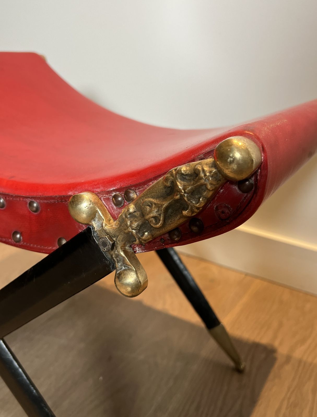 Neoclassical Style Curule Stool In Red Leather And Decorated With Crossed Swords In Bronze And Metal Covered In Black Leather photo vintage