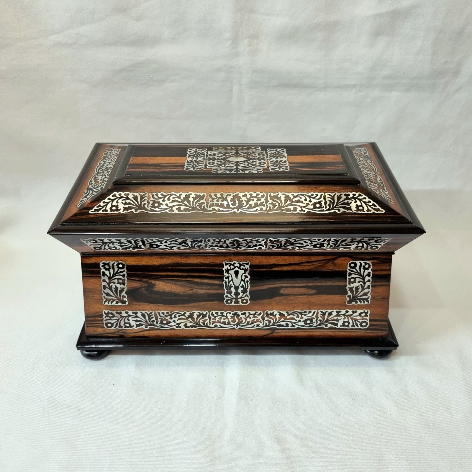 An Exceptionally Fine Quality And Eye Catching Coromandel Tea Caddy Of Large Size & Sarcophagus Shape, Profusely Inlaid With Mother Of Pearl. photo furniture