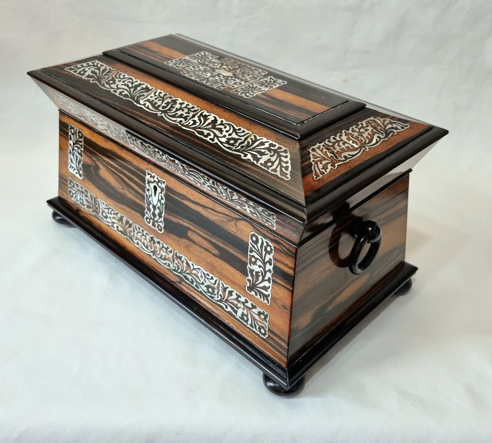 An Exceptionally Fine Quality And Eye Catching Coromandel Tea Caddy Of Large Size & Sarcophagus Shape, Profusely Inlaid With Mother Of Pearl.