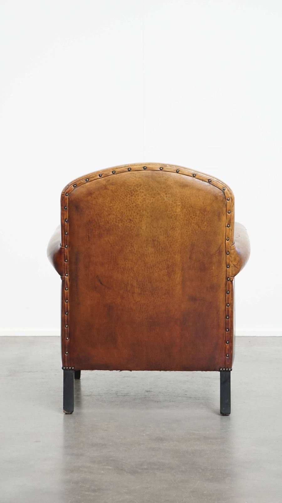 Stylish Sheepskin Designer Armchair In A Warm Cognac Color With A Finish Of Black Piping And Decorative Studs photo Furniture