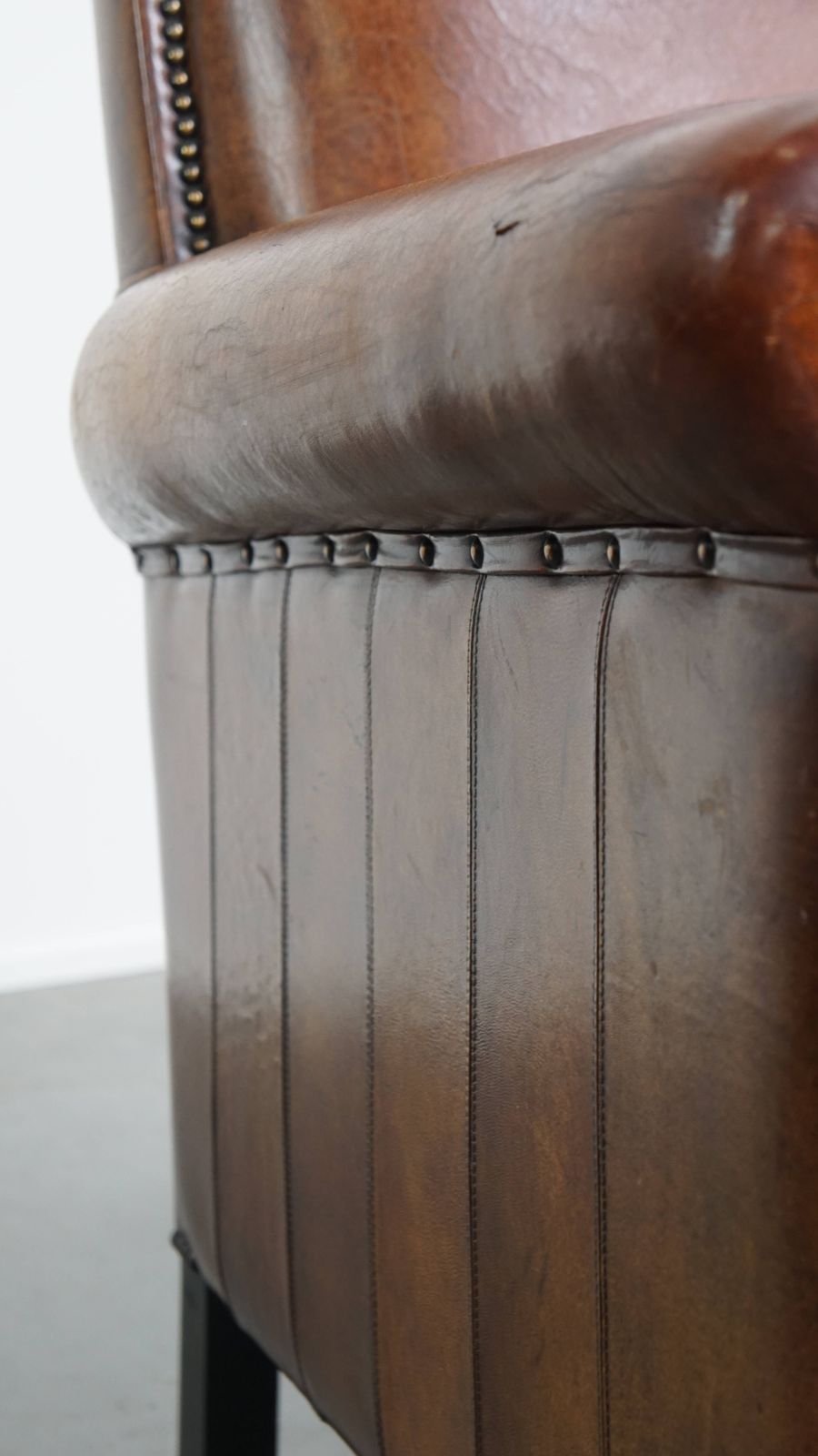 925.0 Stylish Sheepskin Designer Armchair In A Warm Cognac Color With A Finish Of Black Piping And Decorative Studs photo