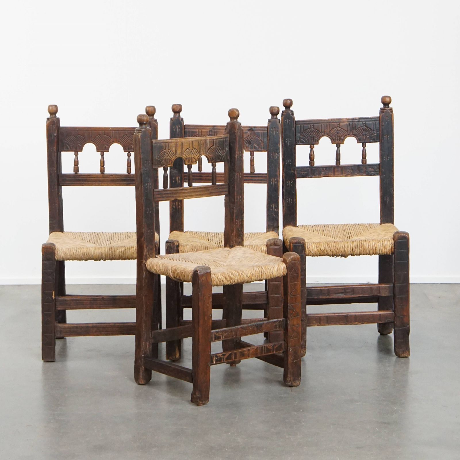 Unique Set Of 4 Antique Spanish Farm Chairs With Woven Wicker Seats And Beautiful Wood Carvings