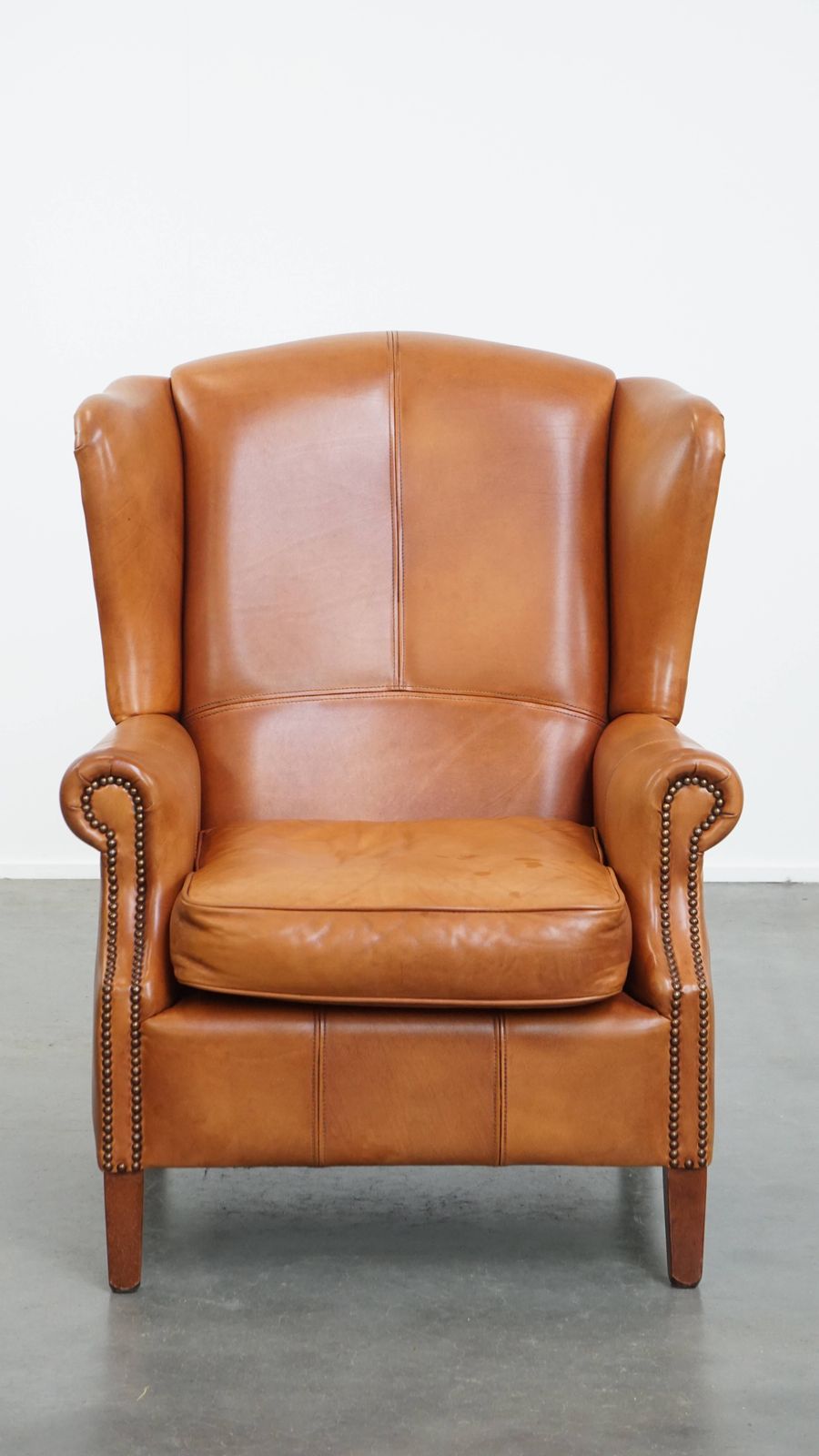 Classic And Unique Cowhide Wing Chair Finished With Decorative Nails And Beautiful Details photo furniture