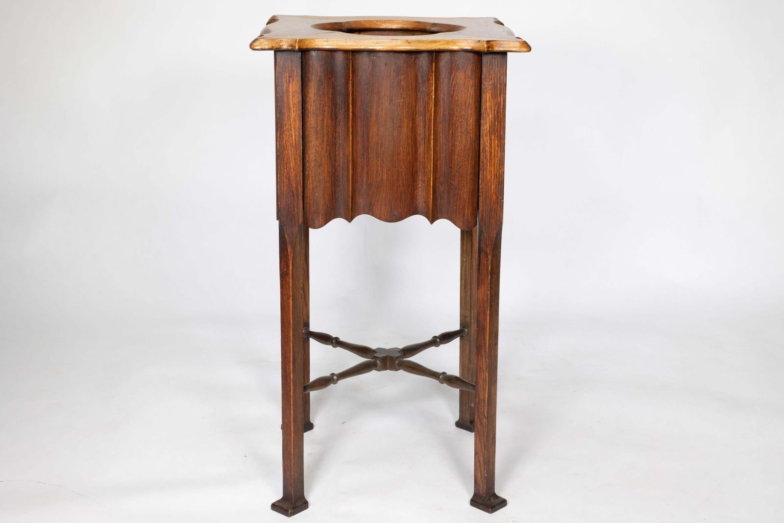 An Arts And Crafts Walnut Plant Stand With A Shaped Top And Ribbed Style Sides photo vinterior