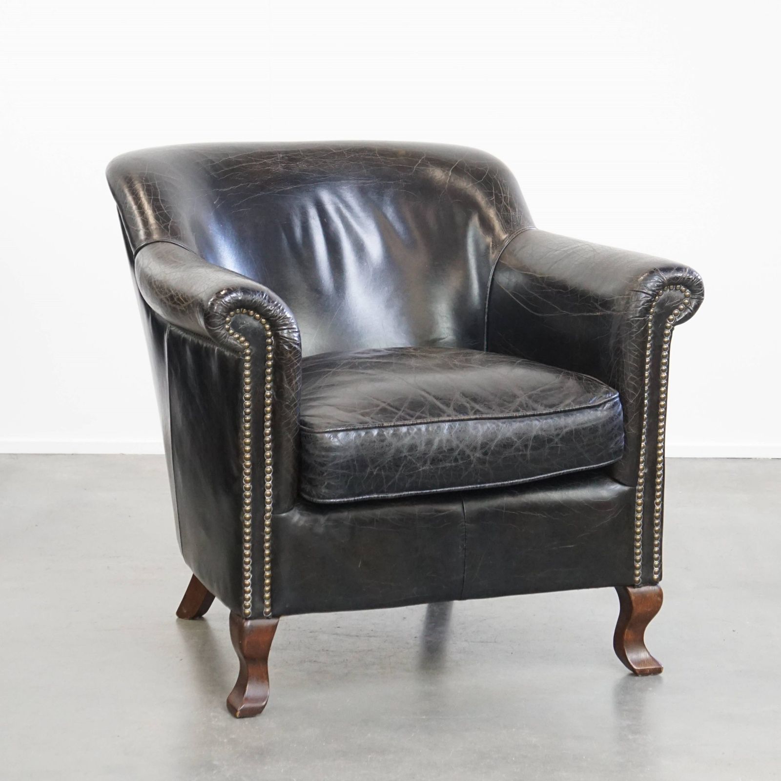Stevige Zwarte Fauteuil Van Gegraneerd Koeienhuid Met Sierlijk Ontwerp