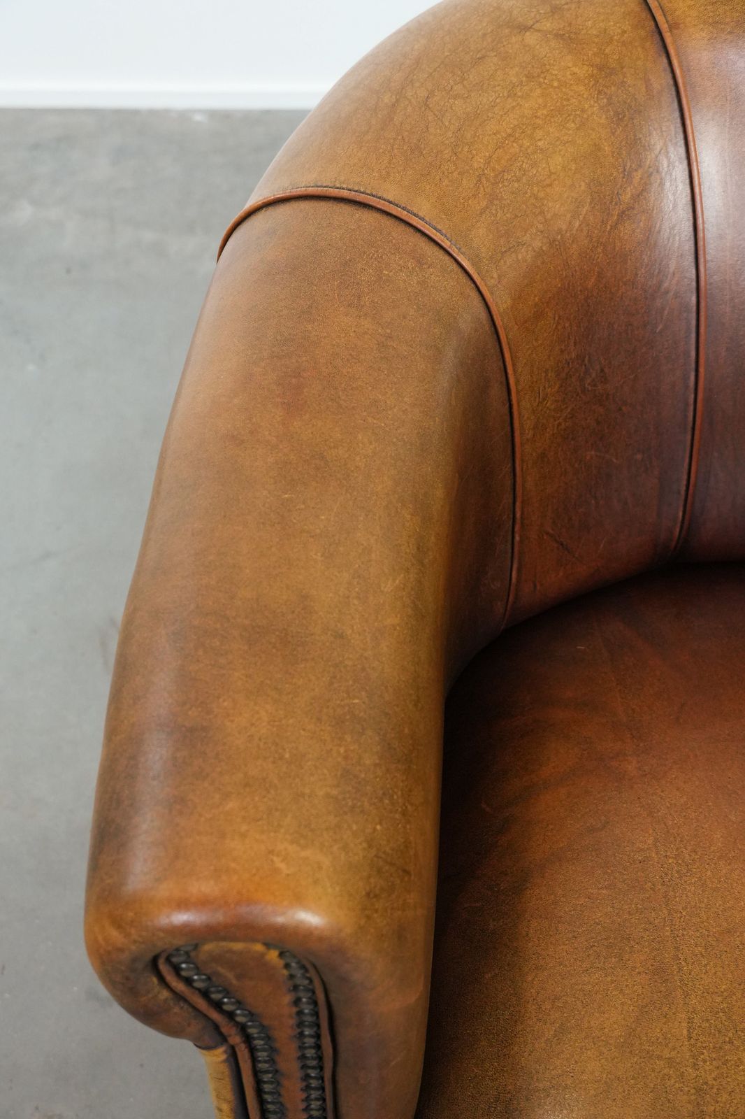 Elegante Schapenvacht Club Fauteuil Met Warme Kleuren, Siernagels En Sierlijk Stiksel photo buy