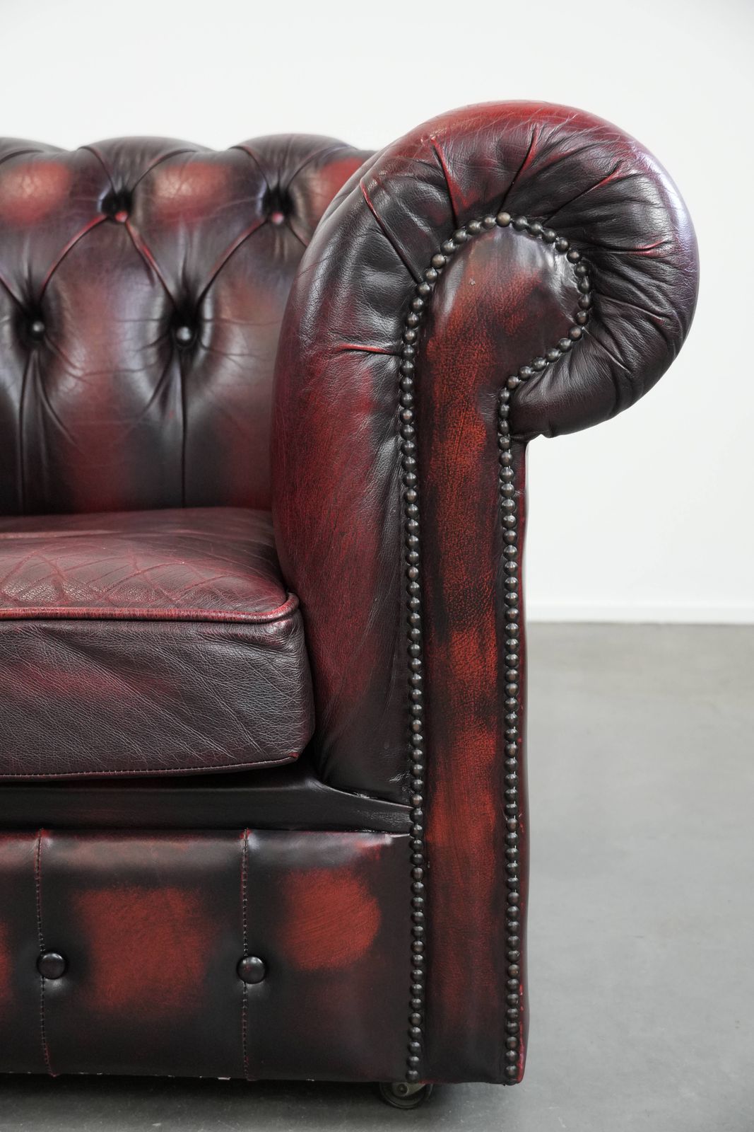 photo furniture Timeless And Classic English Chesterfield Leather Armchair On Wheels, Finished With Decorative Nails
