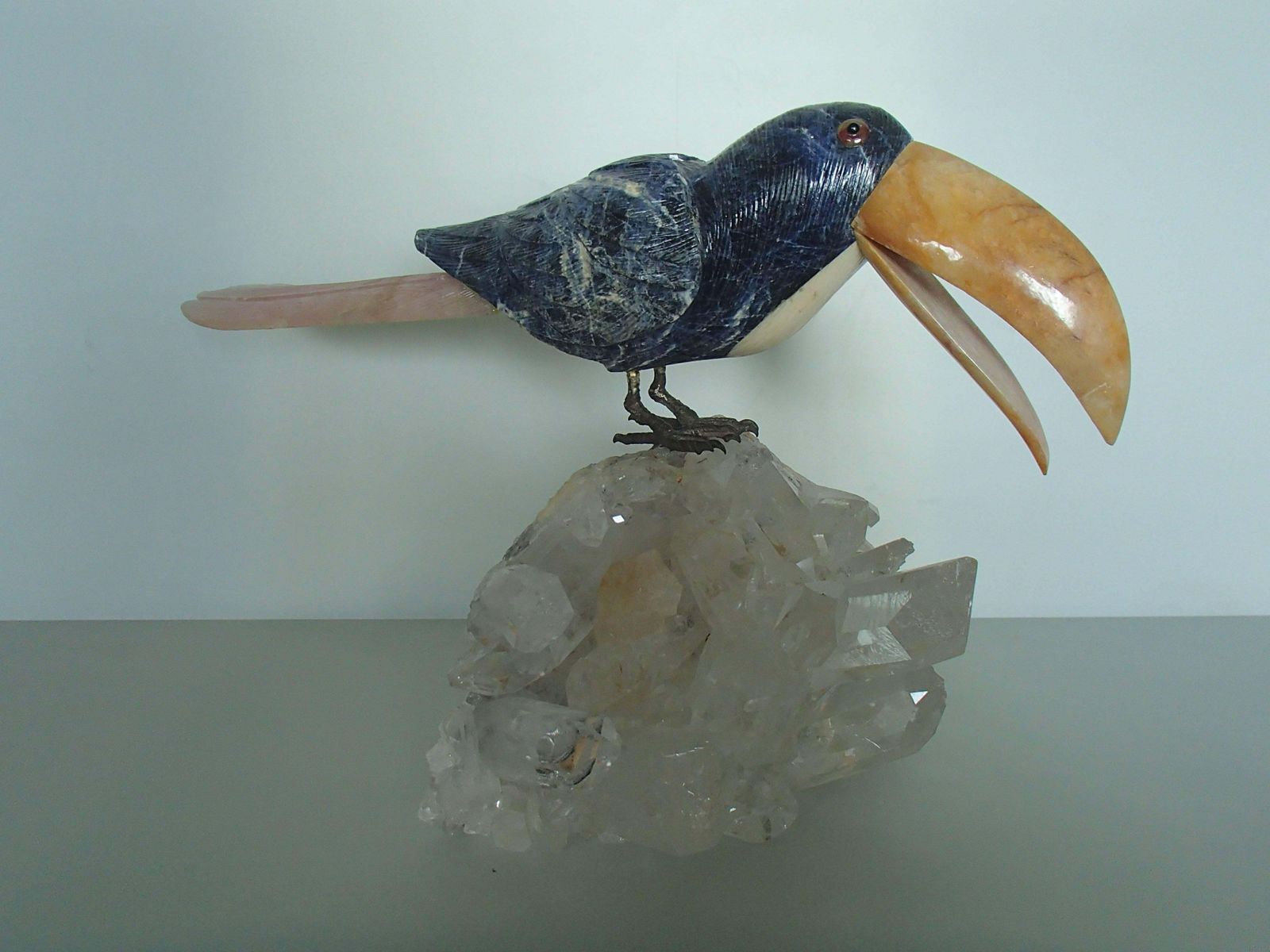 Tucan Sitting On A Cristall Made Of Sodalith And Rose Quarz photo for sale