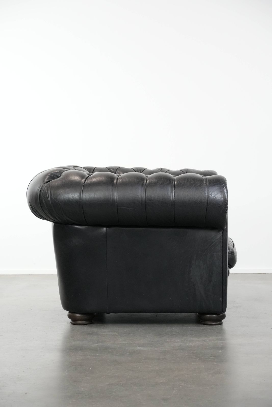 Tijdloze En Comfortabele Zwarte Chesterfield Fauteuil Van Koeienleer photo for sale