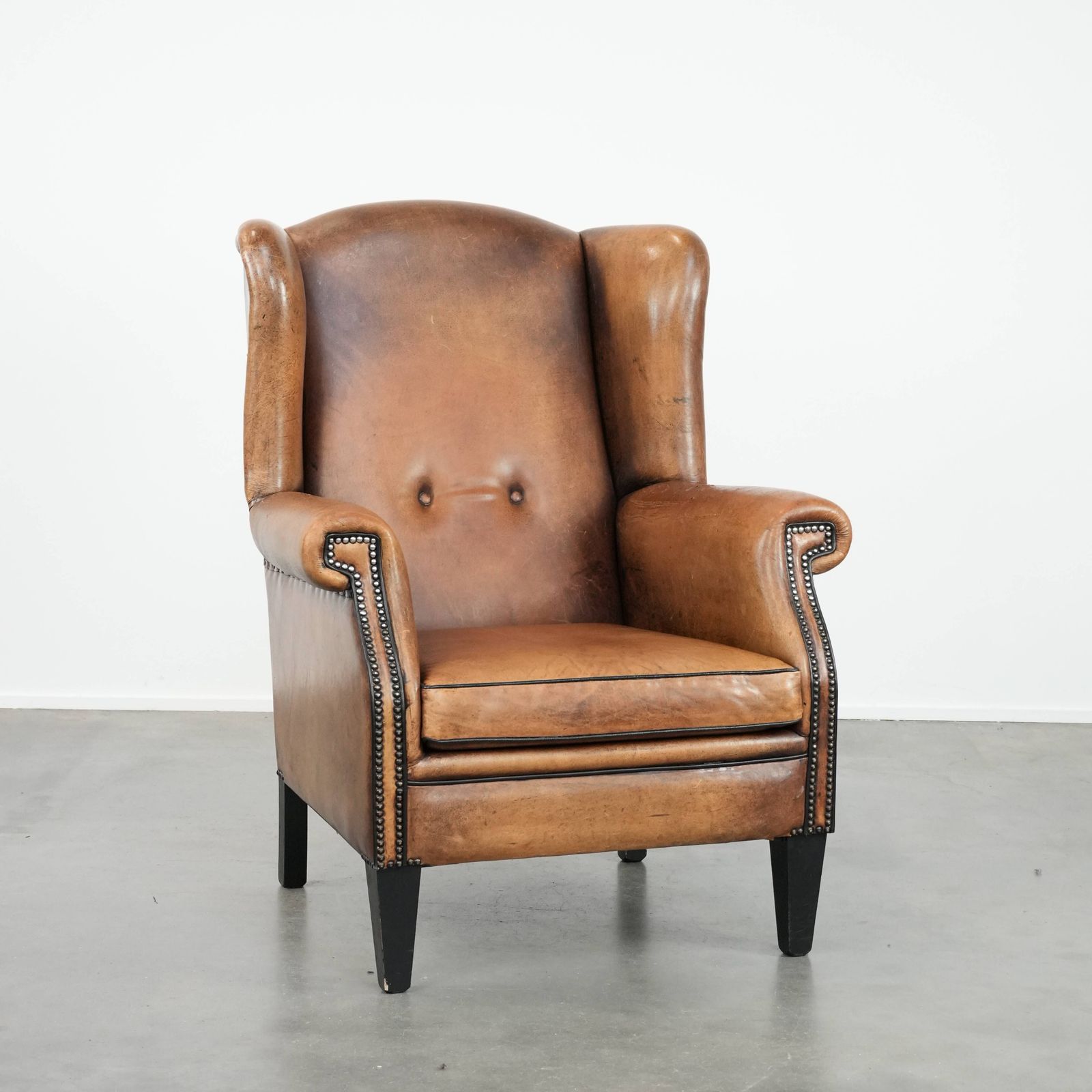 Large And Comfortable Sheepskin Wing Chair With A Characterful Look With Black Piping And Decorative Studs