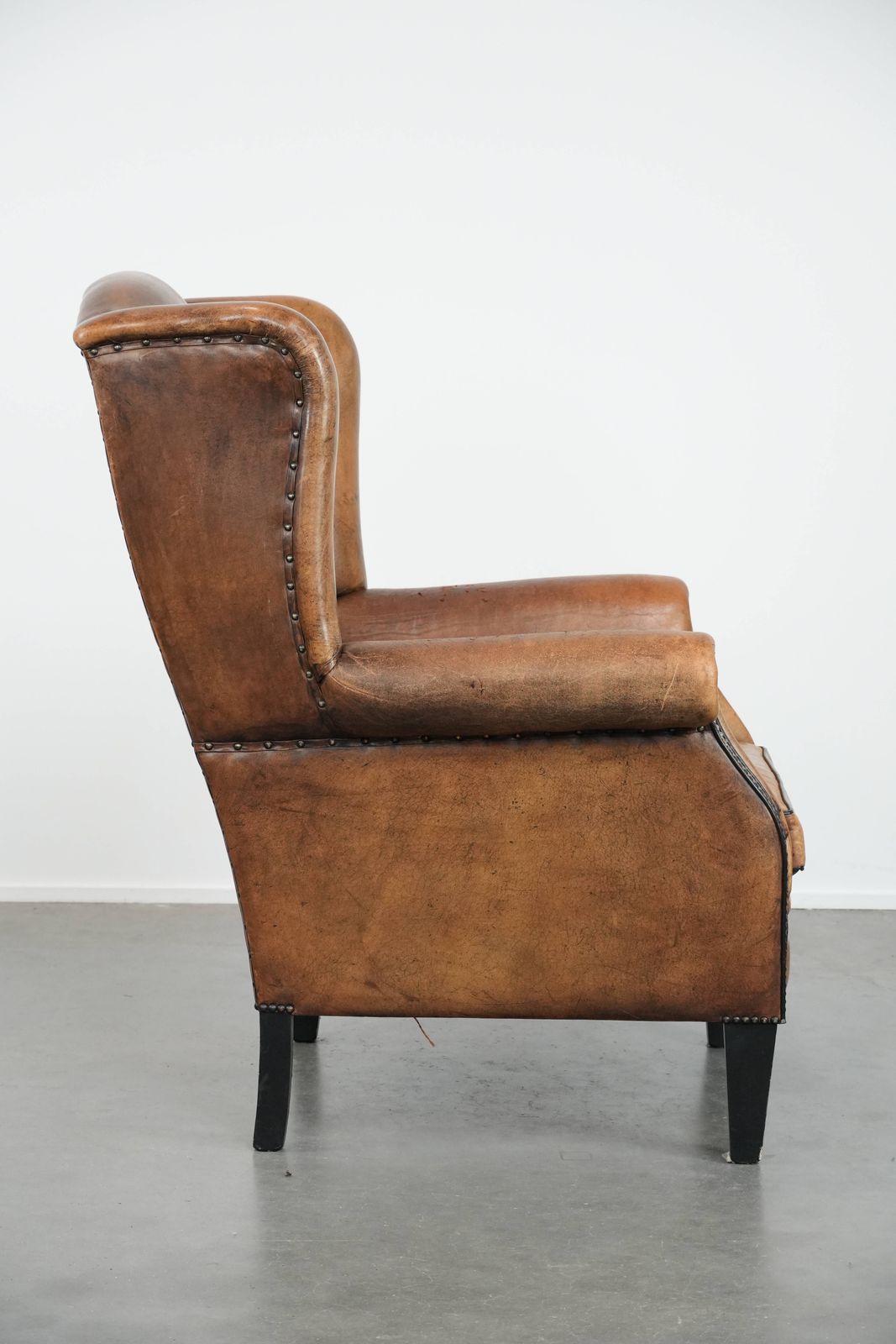 Large And Comfortable Sheepskin Wing Chair With A Characterful Look With Black Piping And Decorative Studs photo for sale
