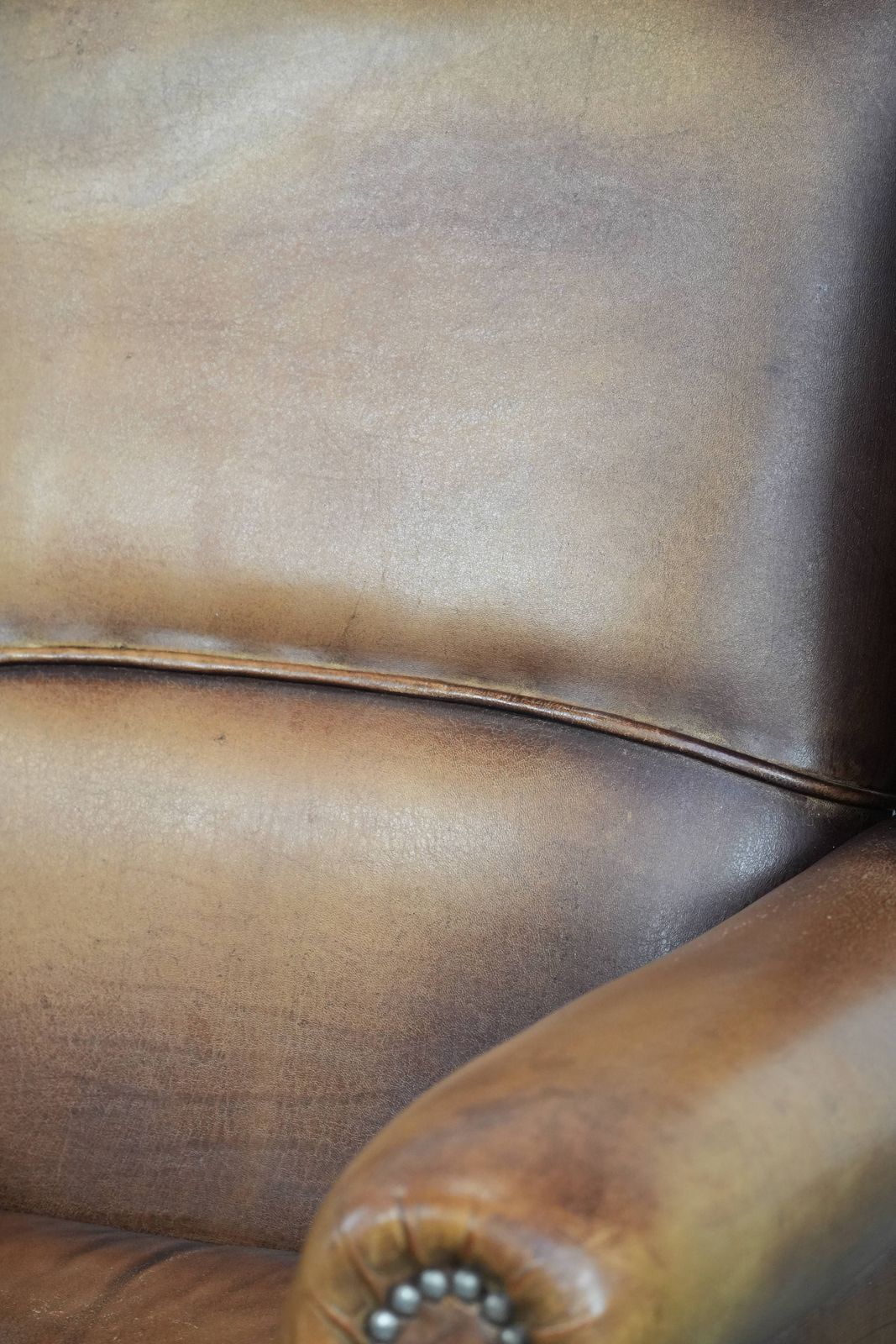photo vinterior Charming Sheepskin Wing Chair With Warm Colours Finished With Decorative Studs