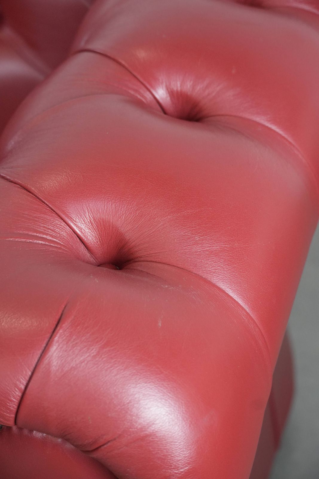photo vintage Engelse 2,5 Zits Chesterfield Bank In Koeienleer, In Een Opvallend Rode Kleur.