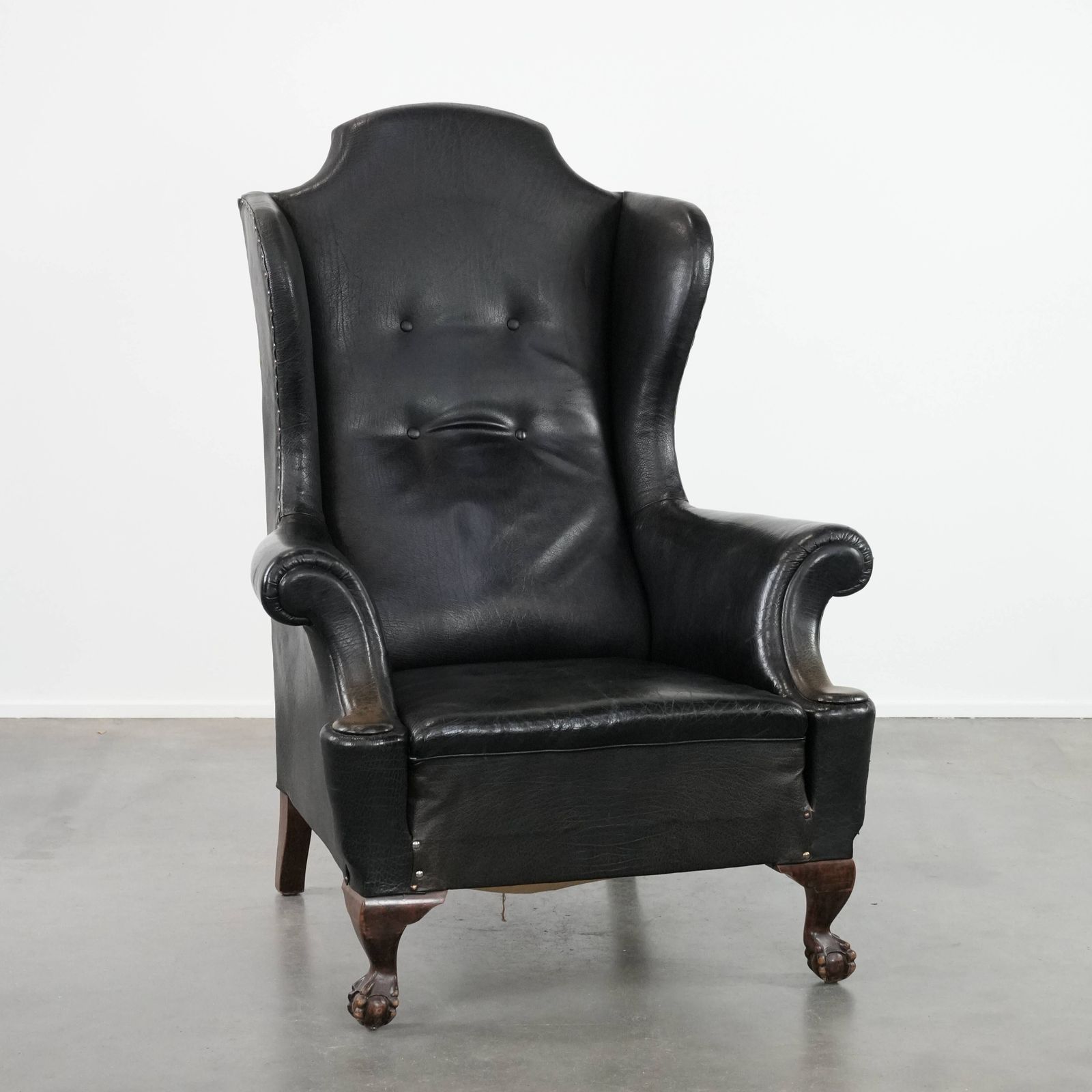 Large Antique Black English Cowhide Wing Chair From The Late 19th Century With A Luxurious Appearance