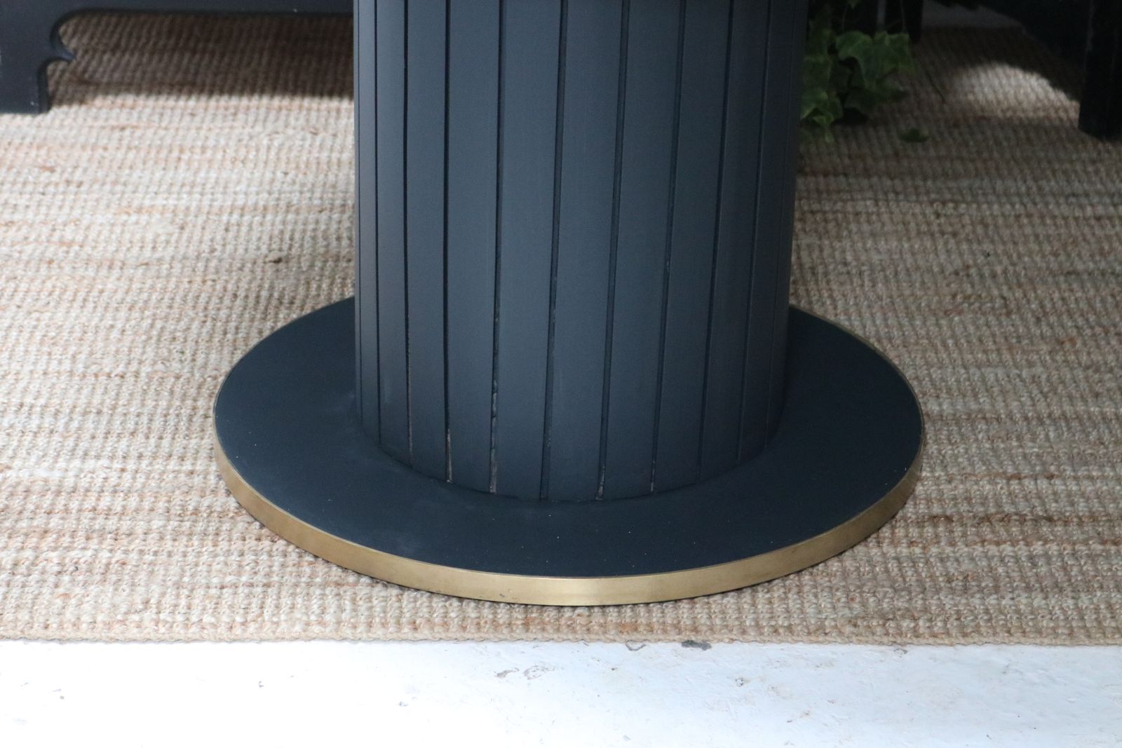 photo vinterior Stunning Black Round Dining Table With Brass Metal Edge Slatted Wood Column Base