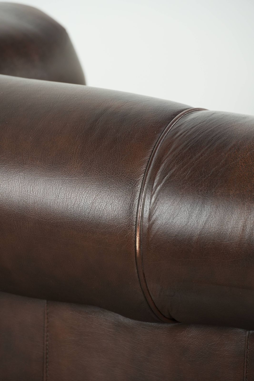photo vintage Luxueuze bruine gladde rundleren Chesterfield-bank met een tijdloze Engelse uitstraling.