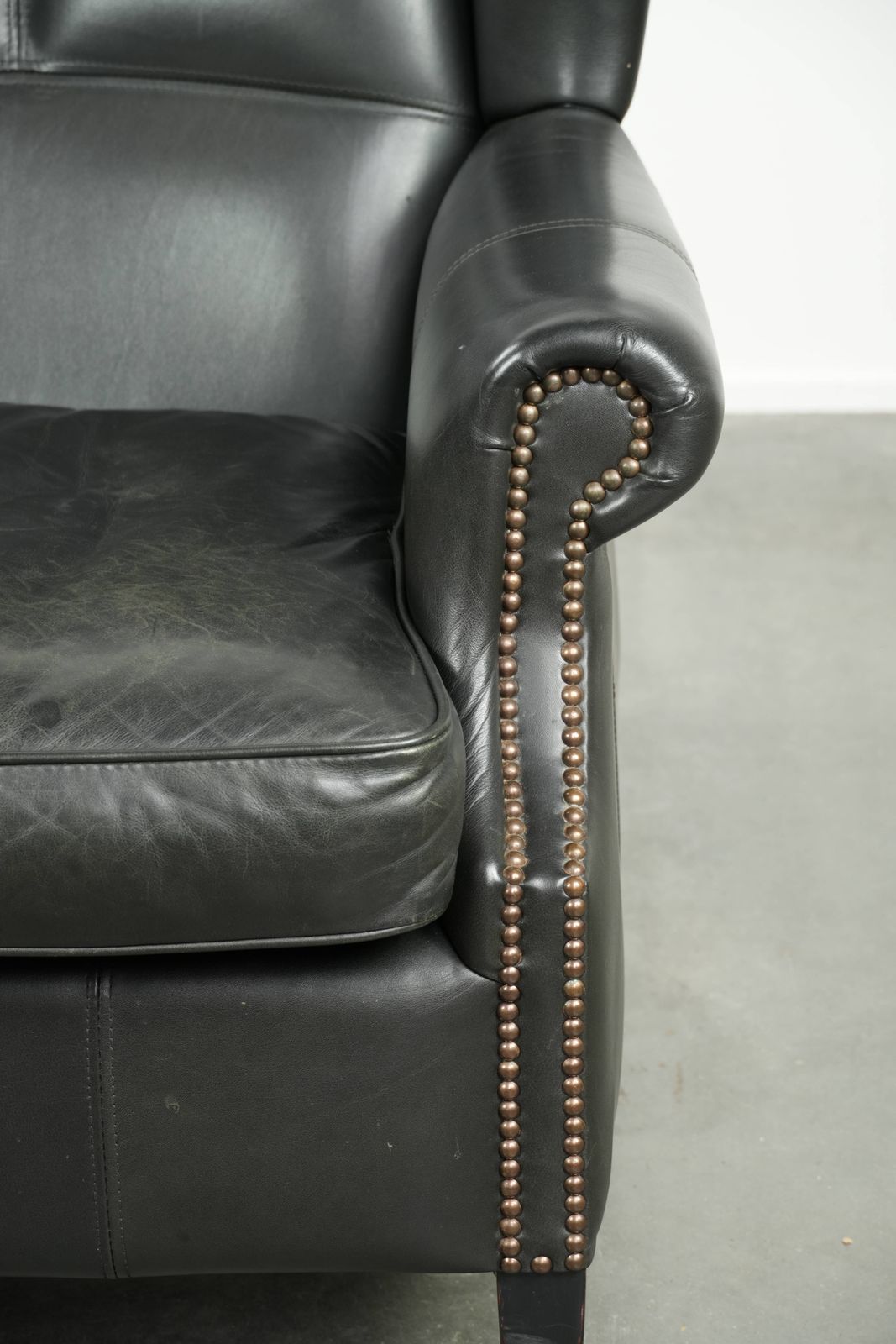 photo furniture Black Cowhide Wing Armchair In A Classic English Style, Finished With Decorative Nails.