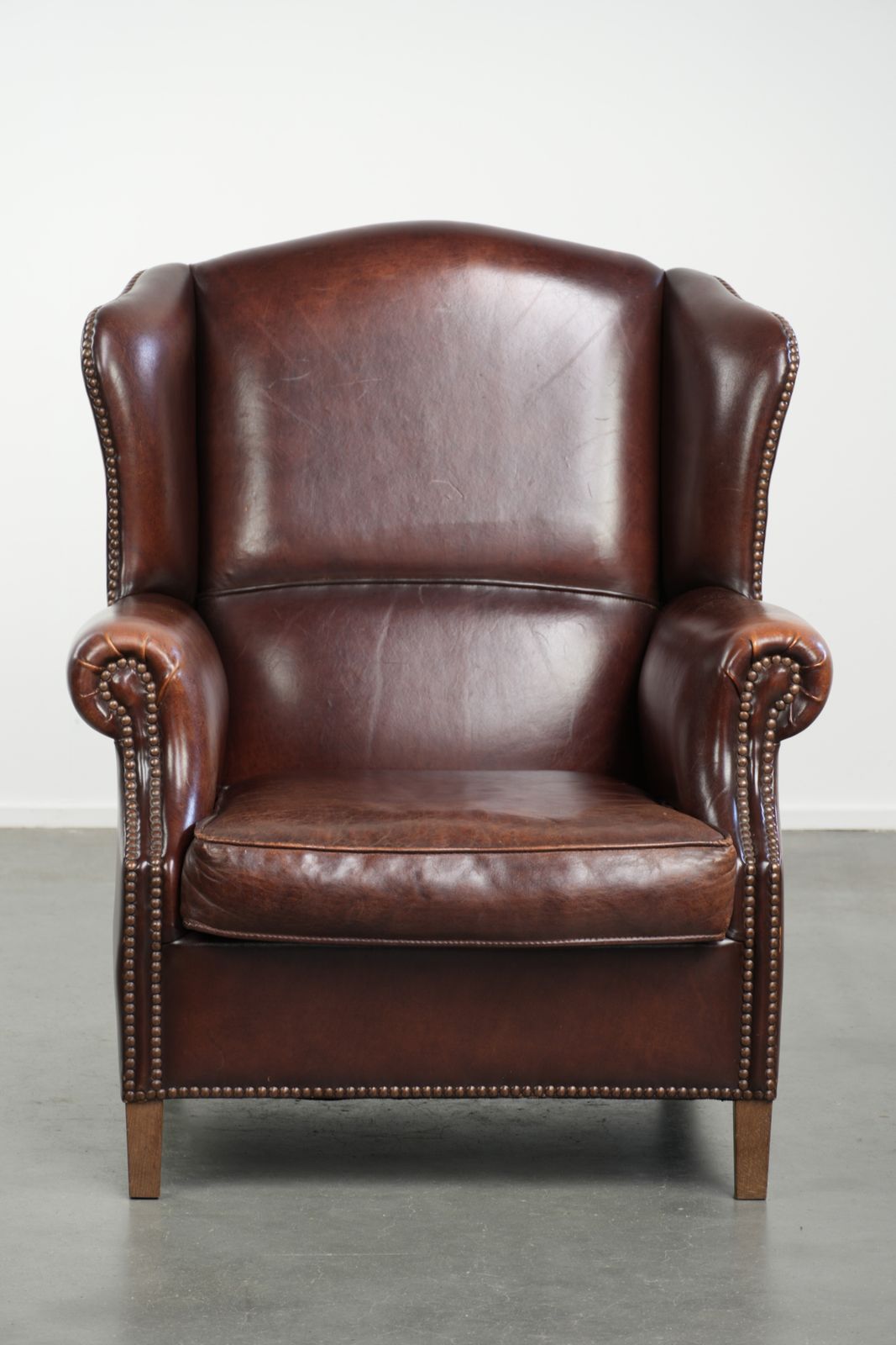 Elegante Vintage Schapenvacht Vleugelfauteuil Met Een Tijdloze Engelse Uitstraling, Afgewerkt Met Decoratieve Sierspijkers. photo furniture