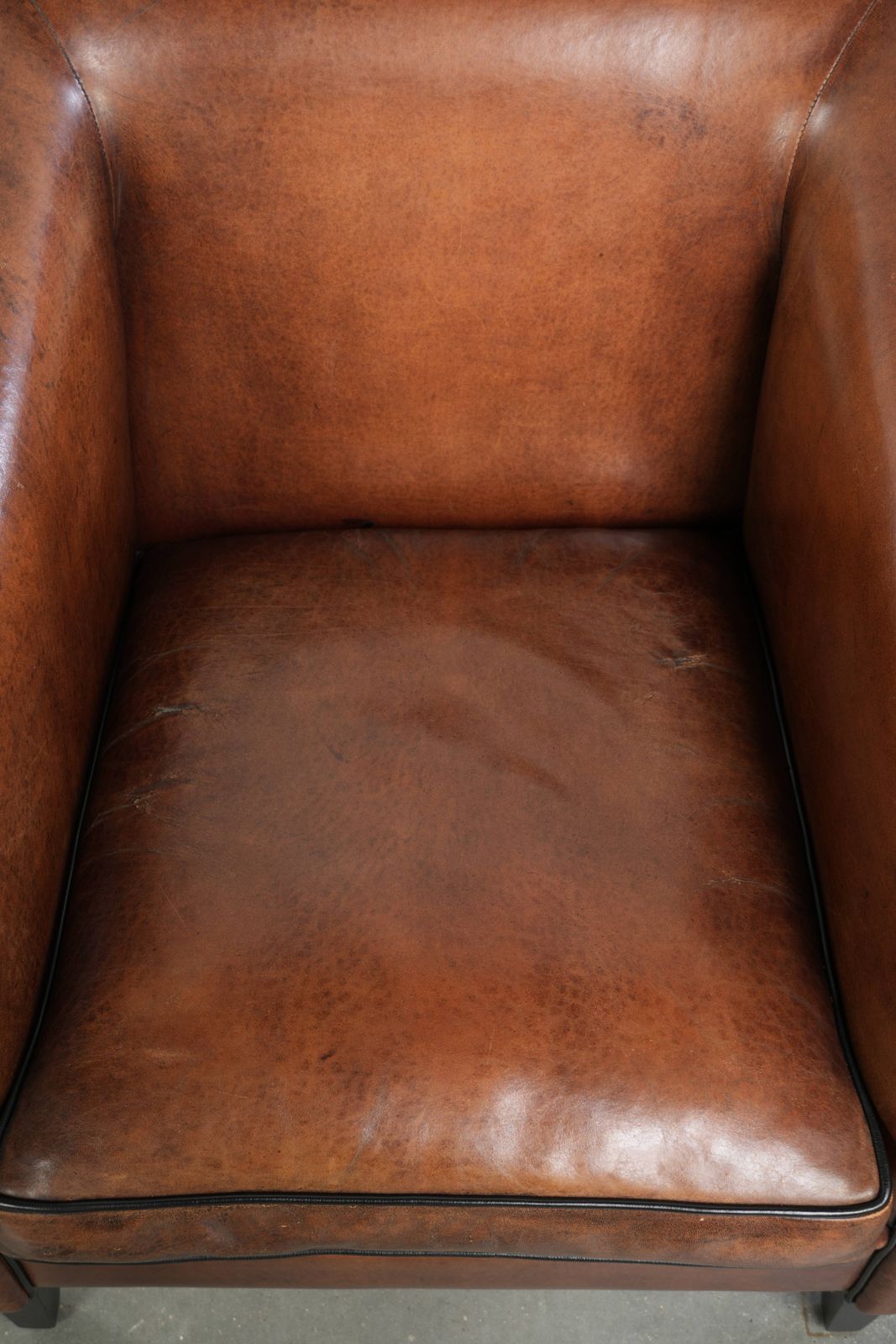 Strakke Art Deco Fauteuil Met Schapenvacht Bekleding, Zwarte Biesjes En Een Mooie Warme Kleur photo vinterior