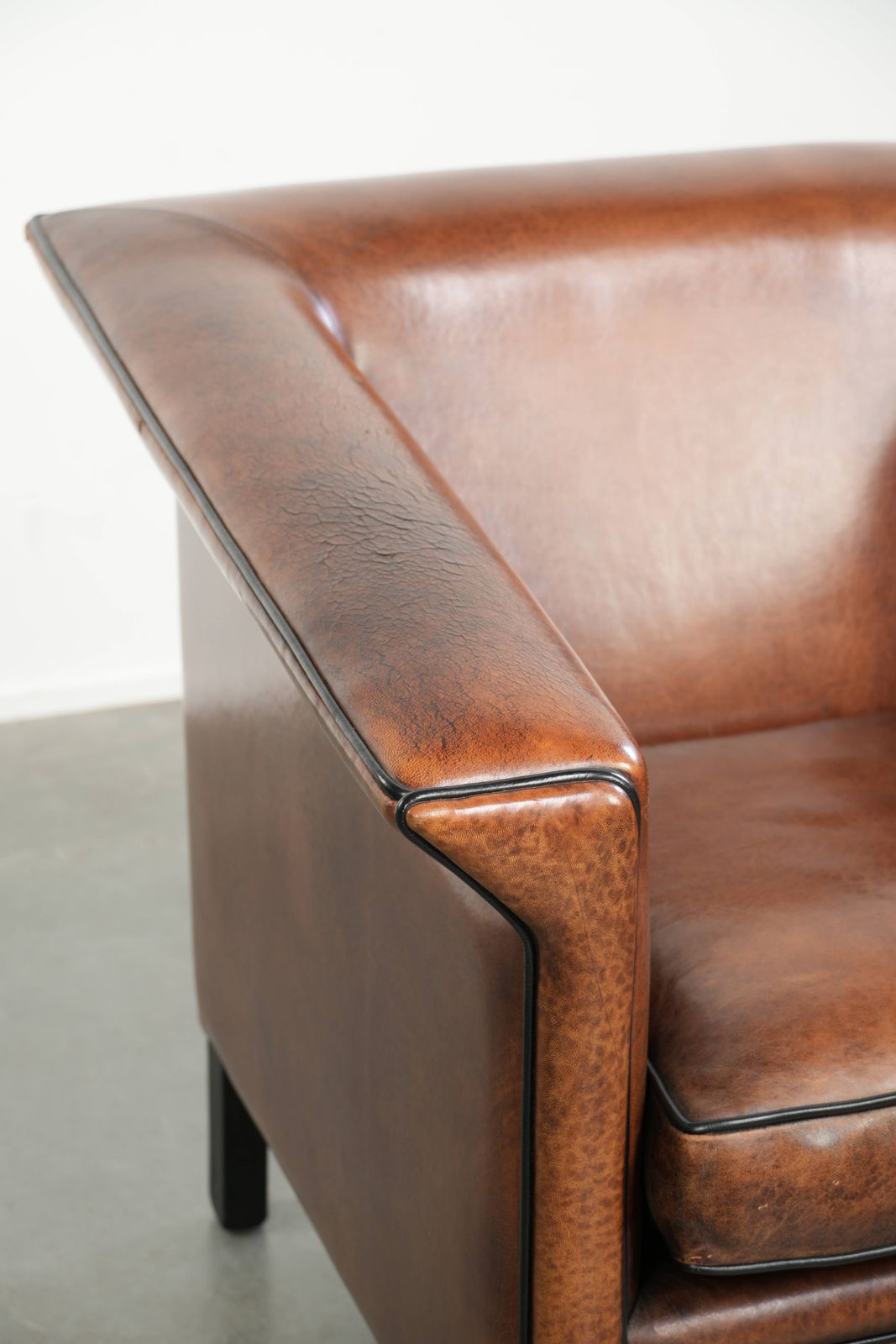 photo furniture Sleek Sheepskin Art Deco Design Armchair With Black Piping And A Beautiful Warm Color