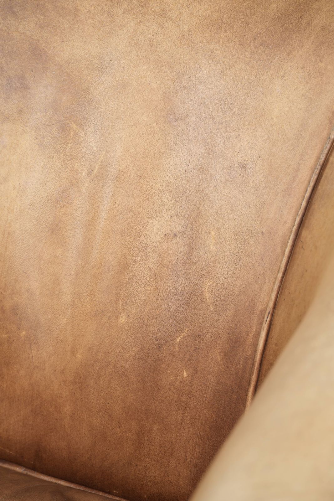 photo vinterior Karaktervolle Vintage Engelse Stijl Clubfauteuil In Koeienhuid Leer Met Een Mooi Licht Kleurenschema