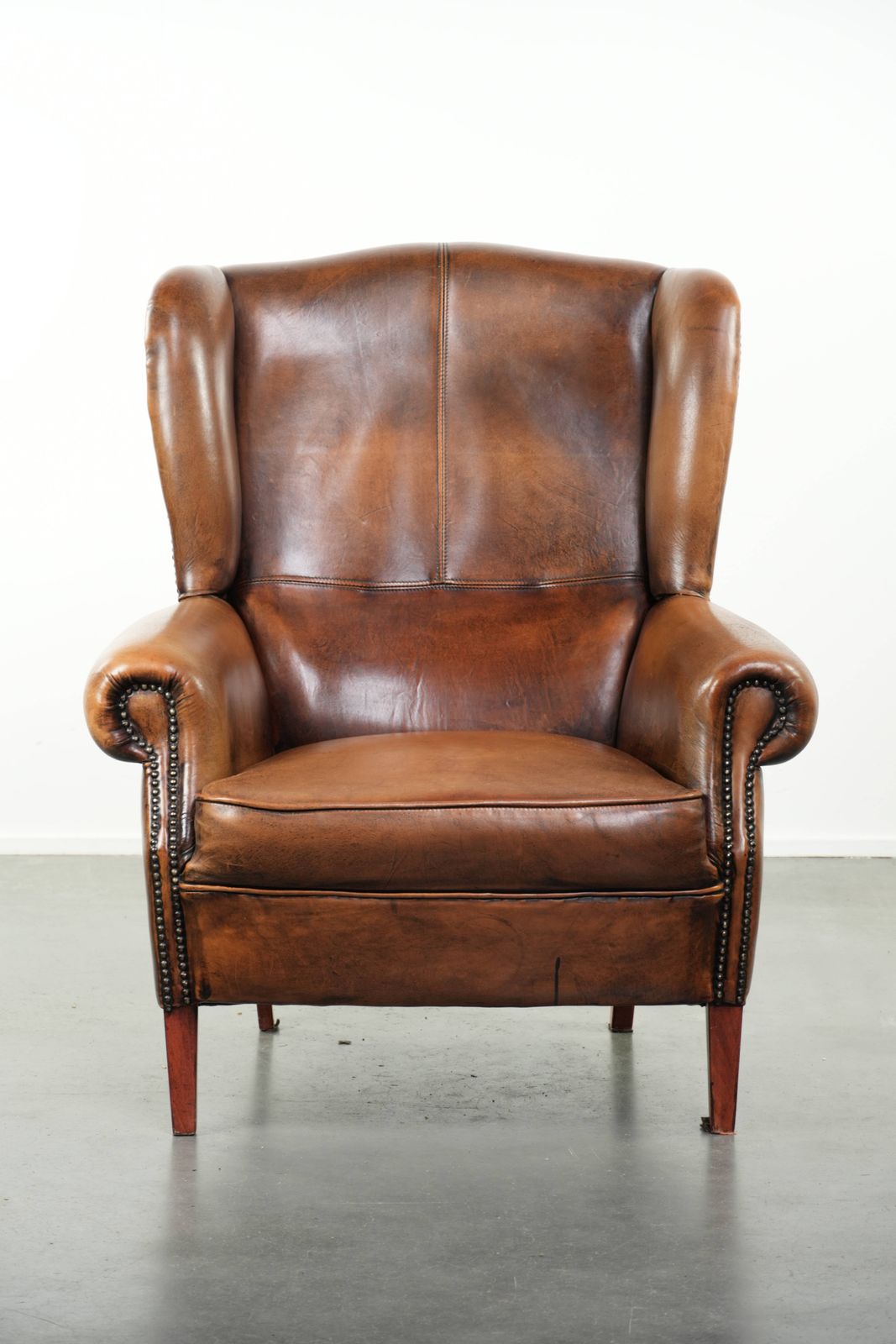 Comfortable Wing Armchair Made Of Sheepskin Finished With Decorative Studs And A Characterful English Style Appearance. photo furniture