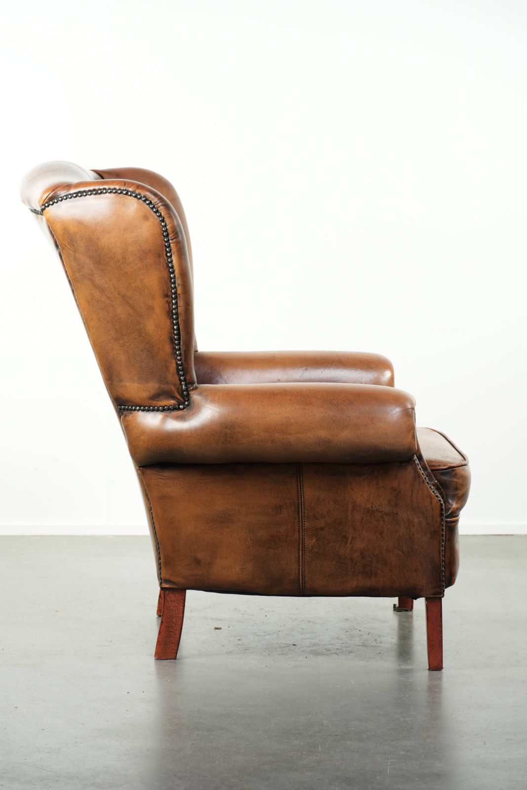 Comfortable Wing Armchair Made Of Sheepskin Finished With Decorative Studs And A Characterful English Style Appearance. photo for sale