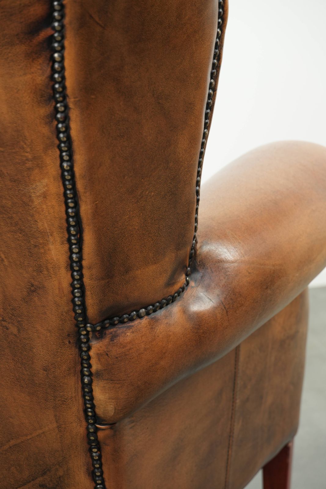 photo vinterior Comfortable Wing Armchair Made Of Sheepskin Finished With Decorative Studs And A Characterful English Style Appearance.