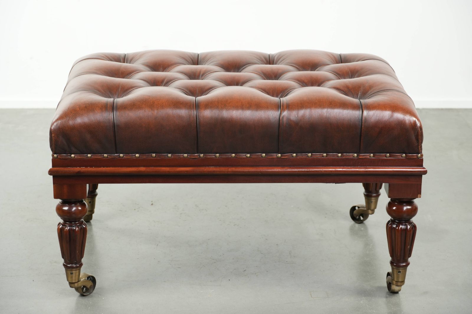 Large Brown Cowhide Chesterfield Ottoman In English Style With Elegant Legs And Brass Casters photo furniture