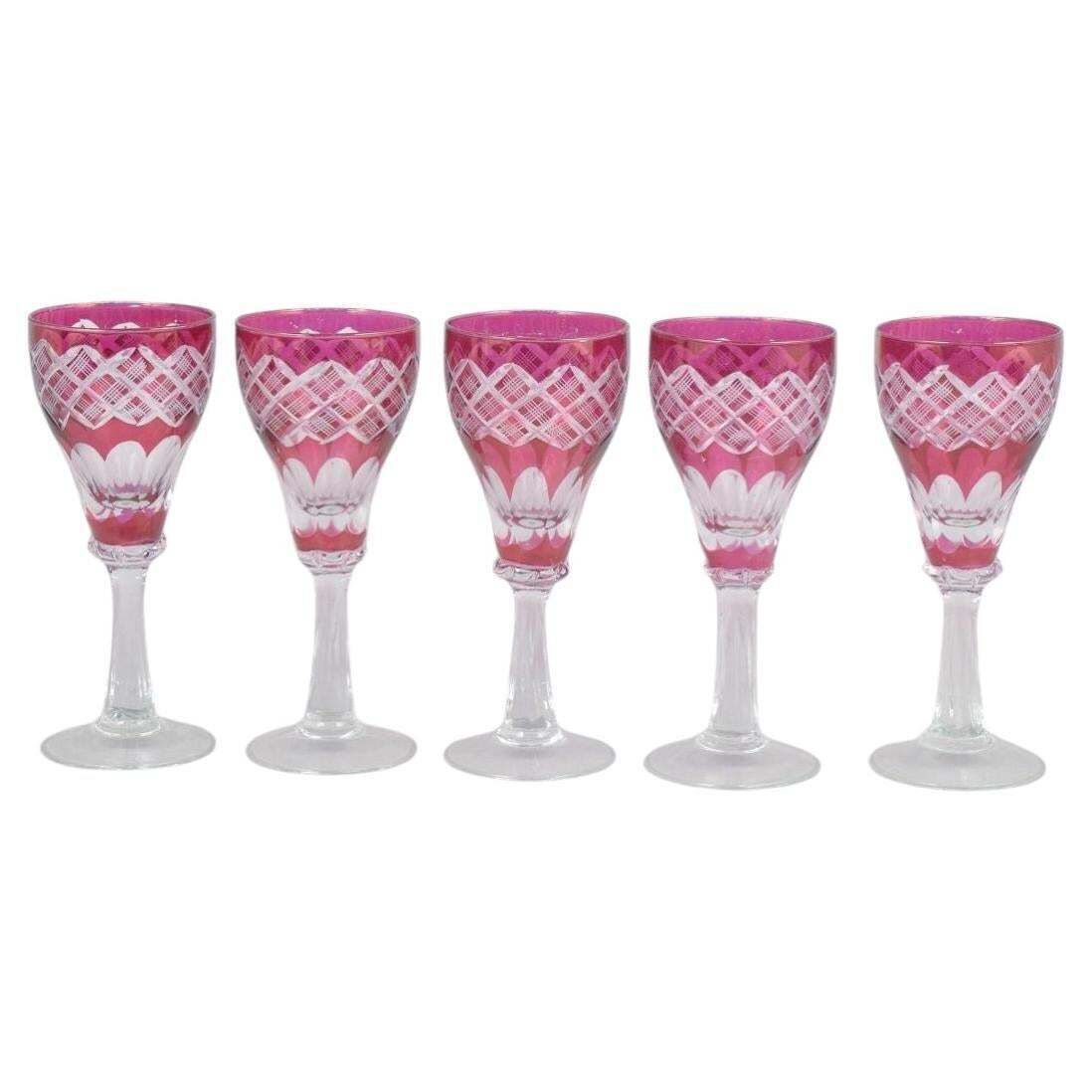 Service de cinq verres à vin en cristal rose de Bohême à décor taillé, années 1940