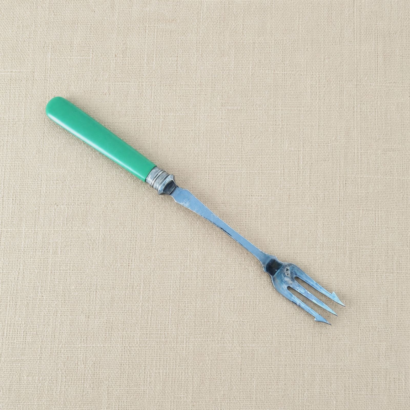 Vintage vork voor augurken en uitjes met groen vroegplastic handvat en EPNS-steel