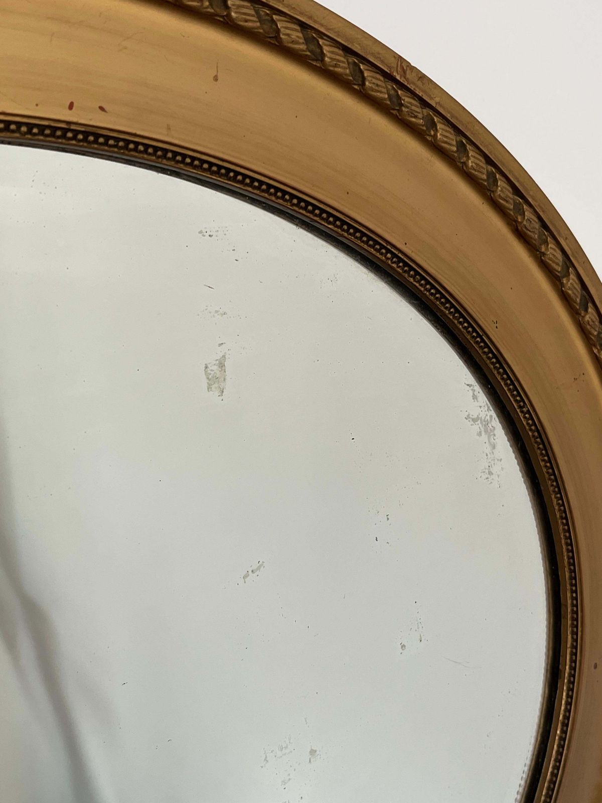 photo furniture Ovale wandspiegel, vergulde lijst met touw- en kralendetail, facetglas, ca. 1890